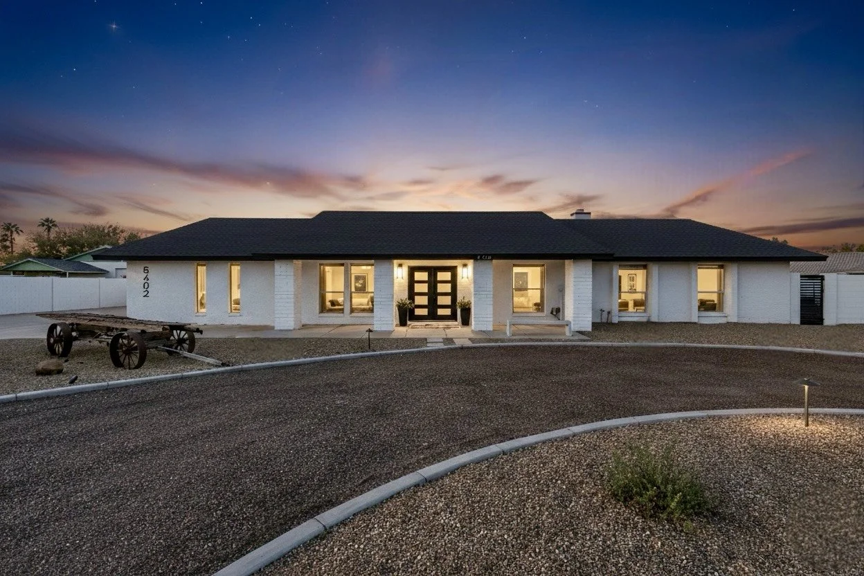 Captivating twilight exterior view of a modern house featuring a circular driveway and warm interior lighting, showcasing stunning real estate photography in Phoenix, AZ.