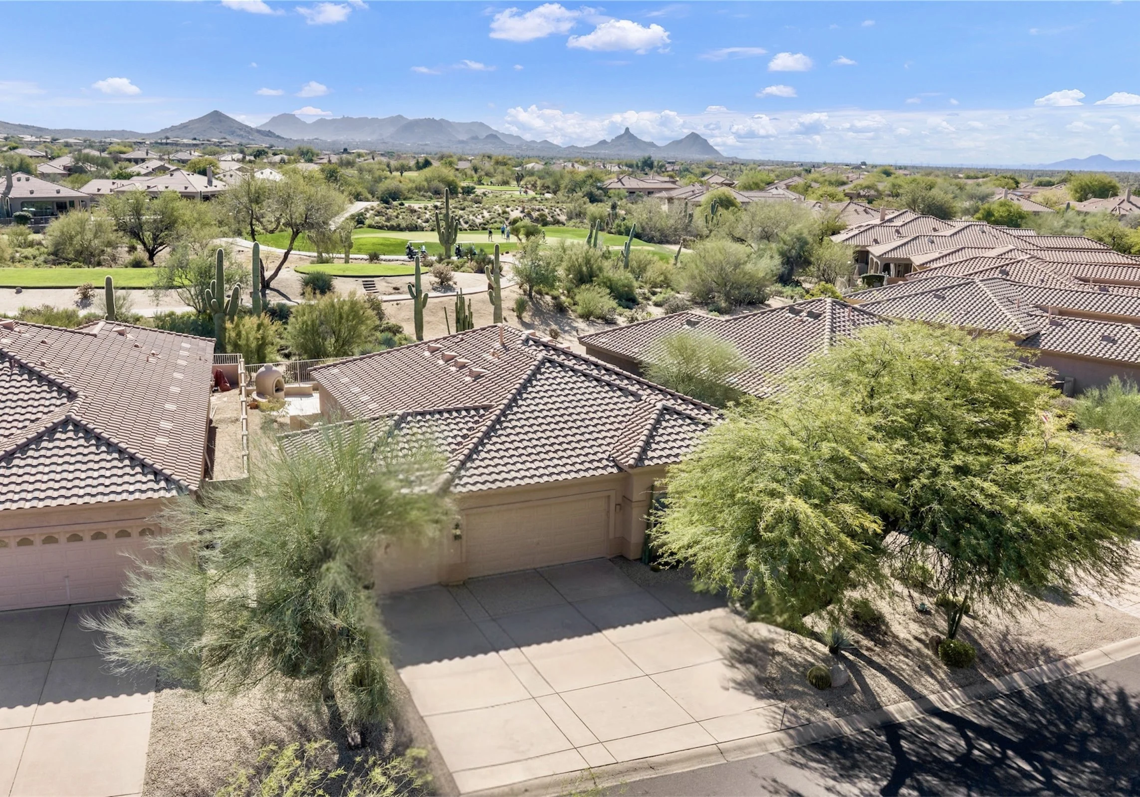 Aerial real estate photography showcasing a suburban neighborhood with a golf course and mountain views in Scottsdale, AZ.