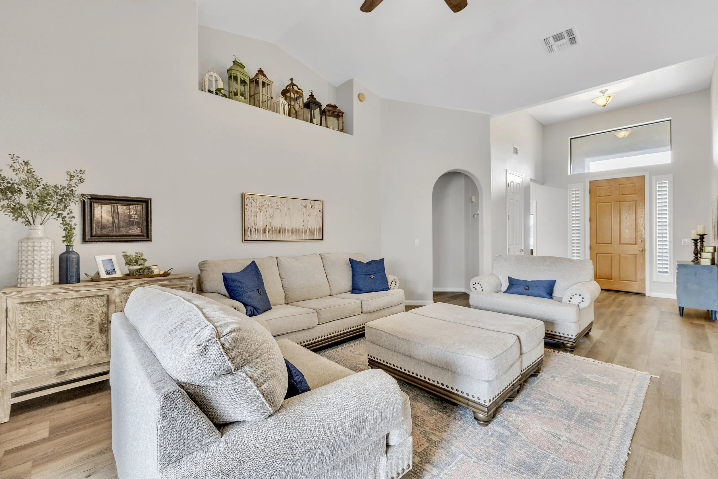 This bright living room in Goodyear, AZ features comfortable seating, neutral decor, and stylish accents, captured with expert real estate photography to highlight its spacious and welcoming atmosphere.