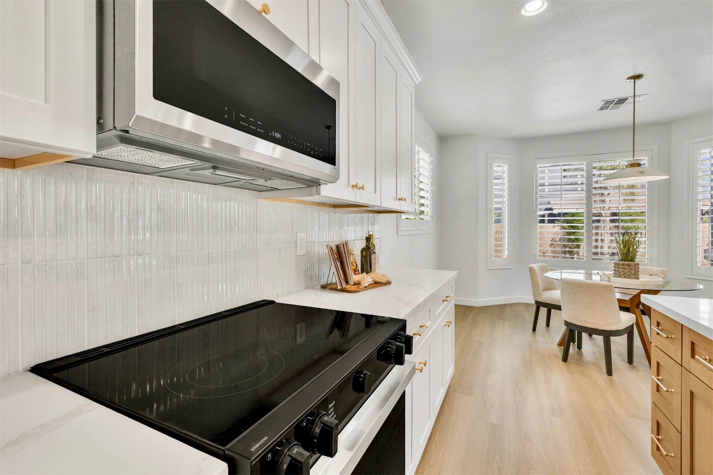 This modern kitchen in Gilbert, AZ features a sleek stove, microwave, and a bright breakfast area, captured with professional real estate photography in the Morrison Ranch neighborhood.