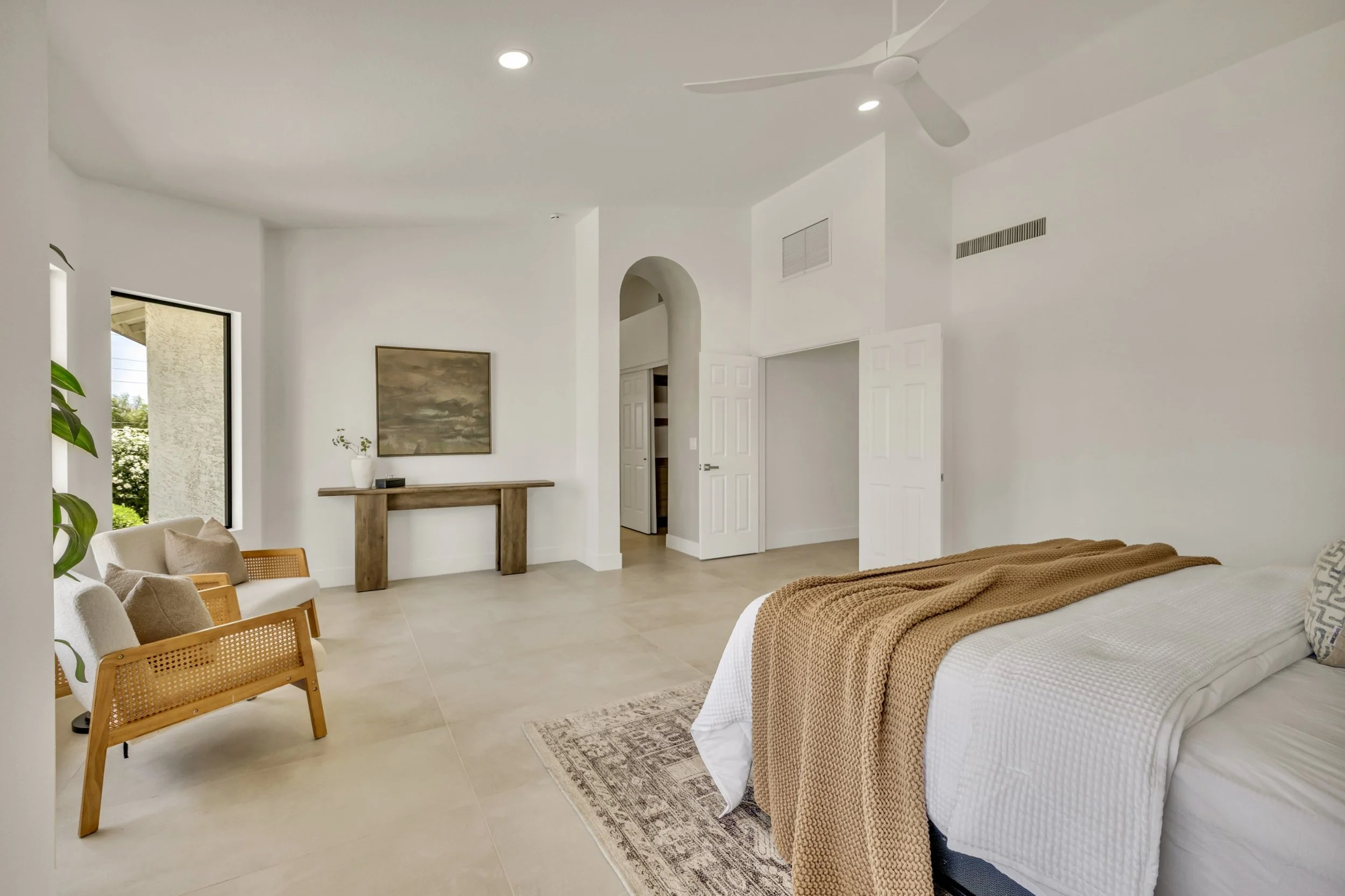 This bright bedroom in Scottsdale, AZ features minimalist decor and modern furnishings, showcased perfectly through expert real estate photography.