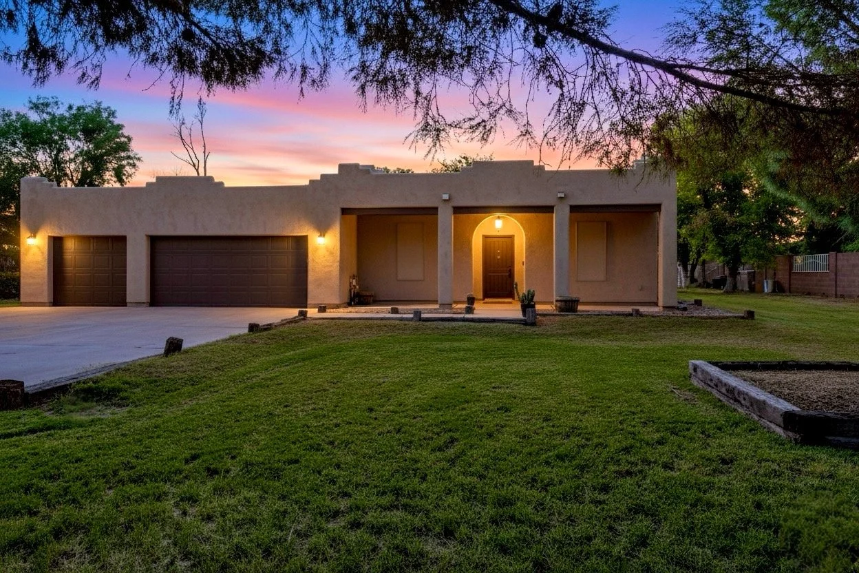 Beautiful twilight exterior of a residential home in Phoenix, AZ, captured with expert real estate photography showcasing warm lighting and spacious front yard.