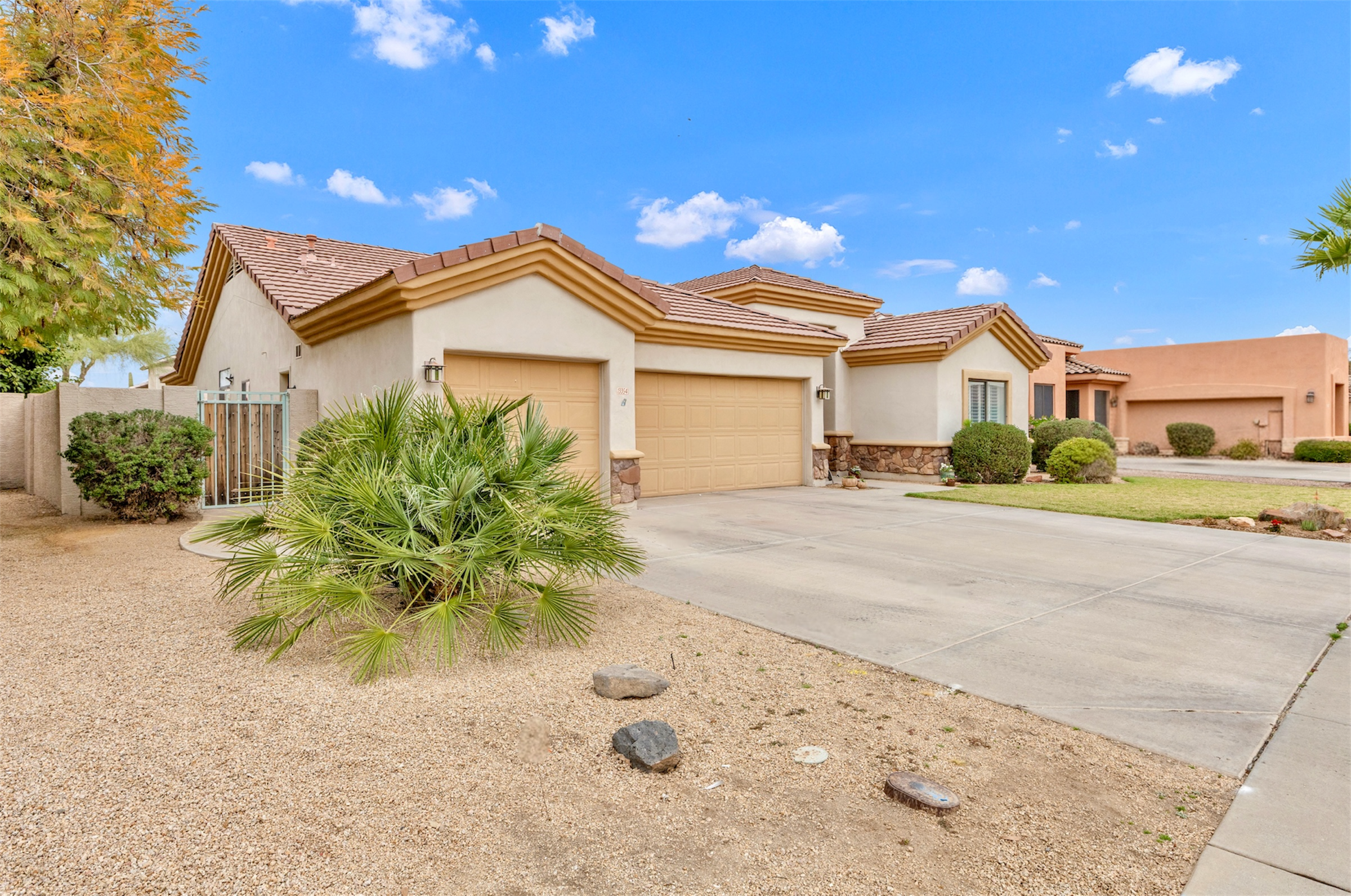 This Goodyear, AZ home features a spacious driveway and three-car garage, captured with professional real estate photography for an appealing suburban exterior view.