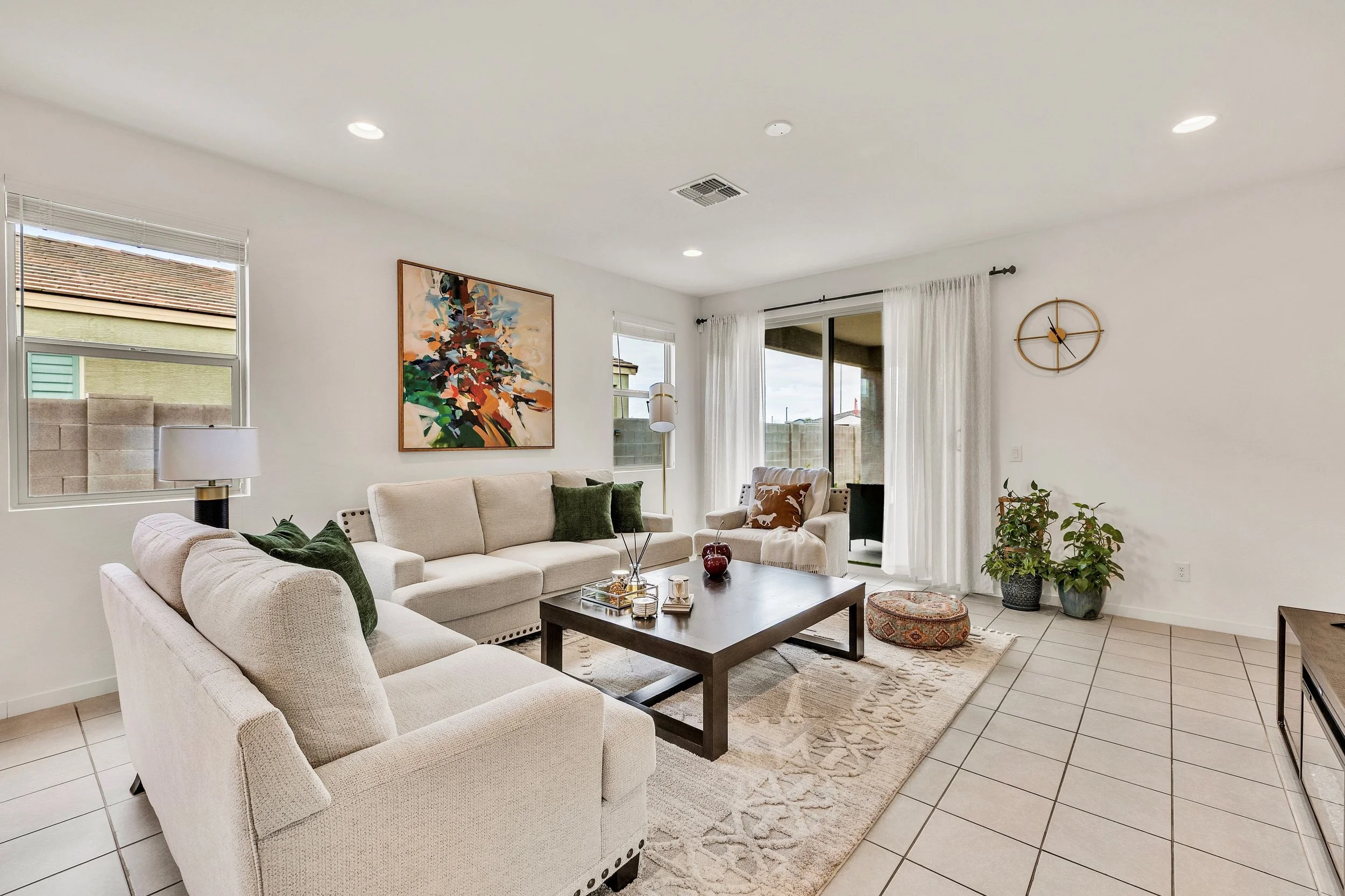 This bright living room in San Tan Valley, AZ features tiled flooring, cozy furnishings, and ample natural light, captured with professional real estate photography.