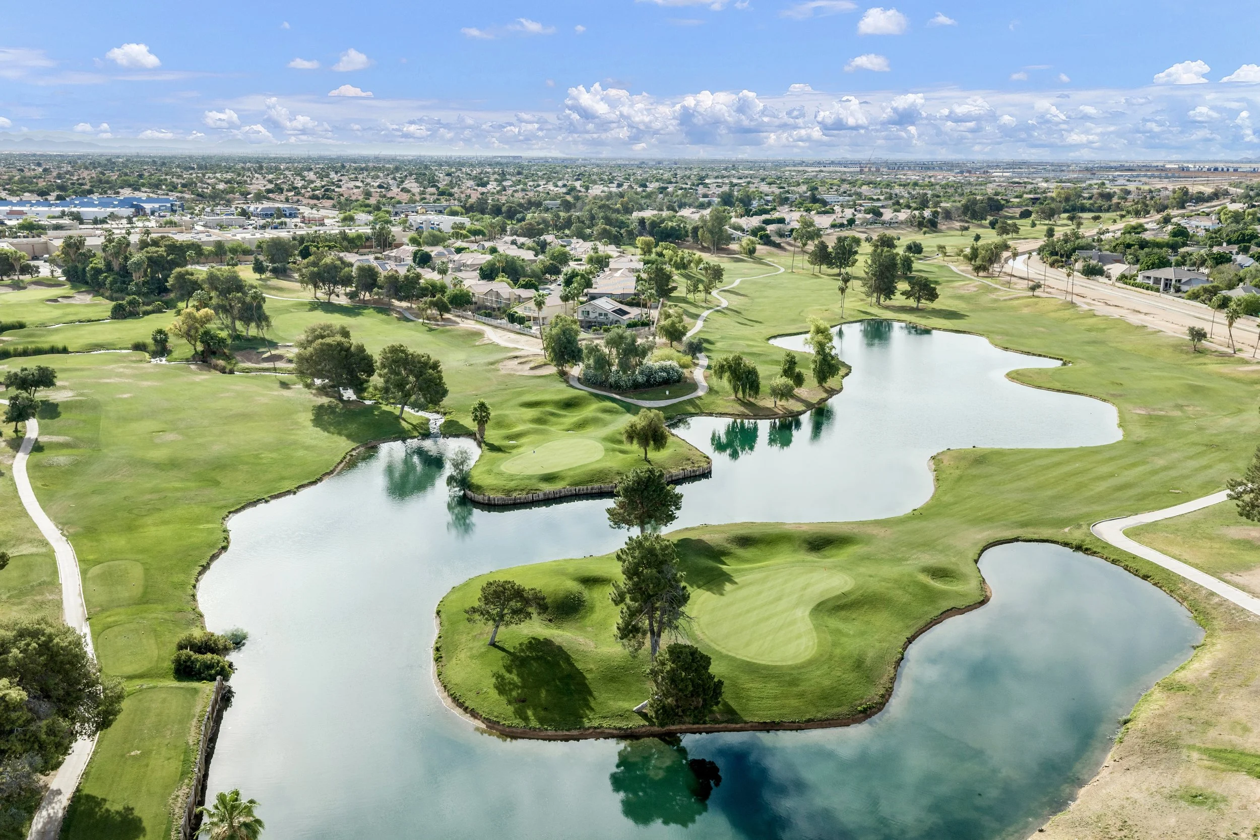 Aerial real estate photography capturing a golf course with lakes and greenery in Gilbert, AZ, showcasing a scenic and expansive outdoor view ideal for luxury homes.