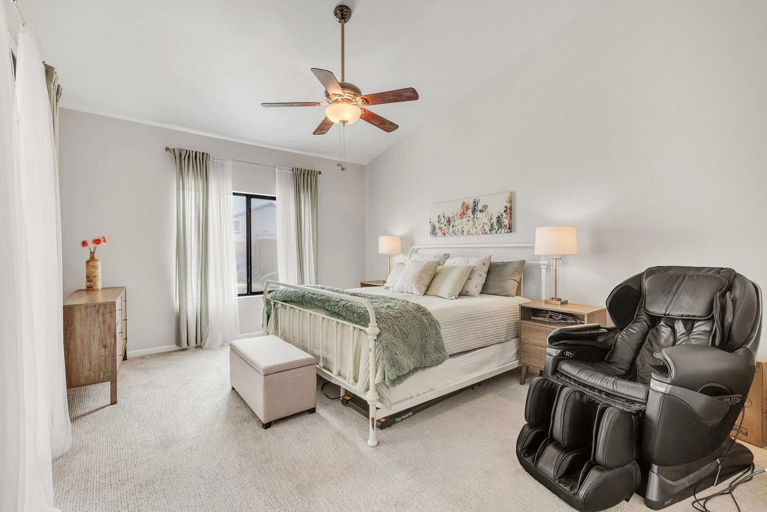 This Goodyear, AZ bedroom features a cozy bed, comfortable seating, and natural light, captured with professional real estate photography to showcase its inviting atmosphere.
