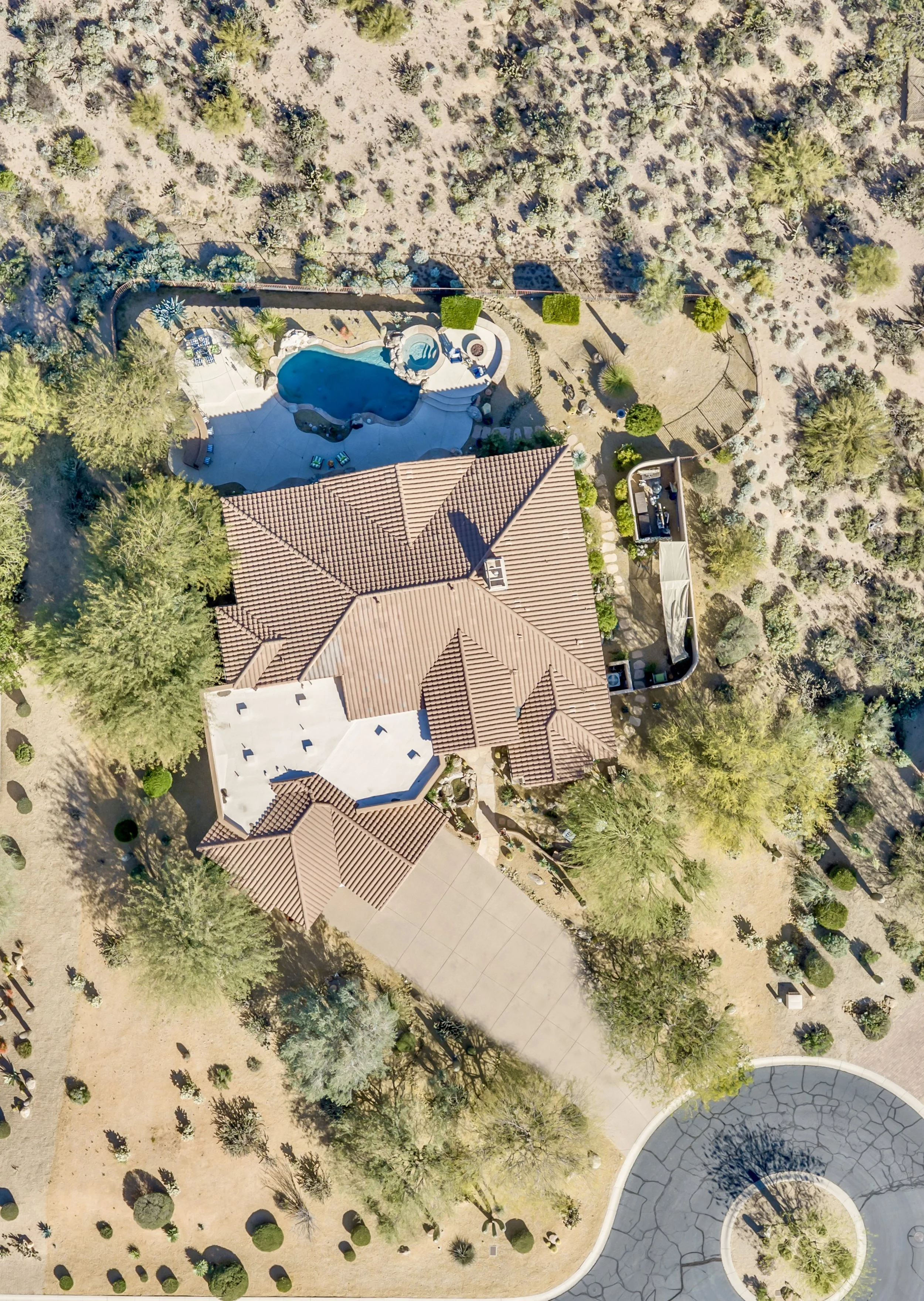 Aerial real estate photography captures a beautiful Scottsdale, AZ home with a pool, spacious backyard, and desert landscaping perfect for outdoor living.