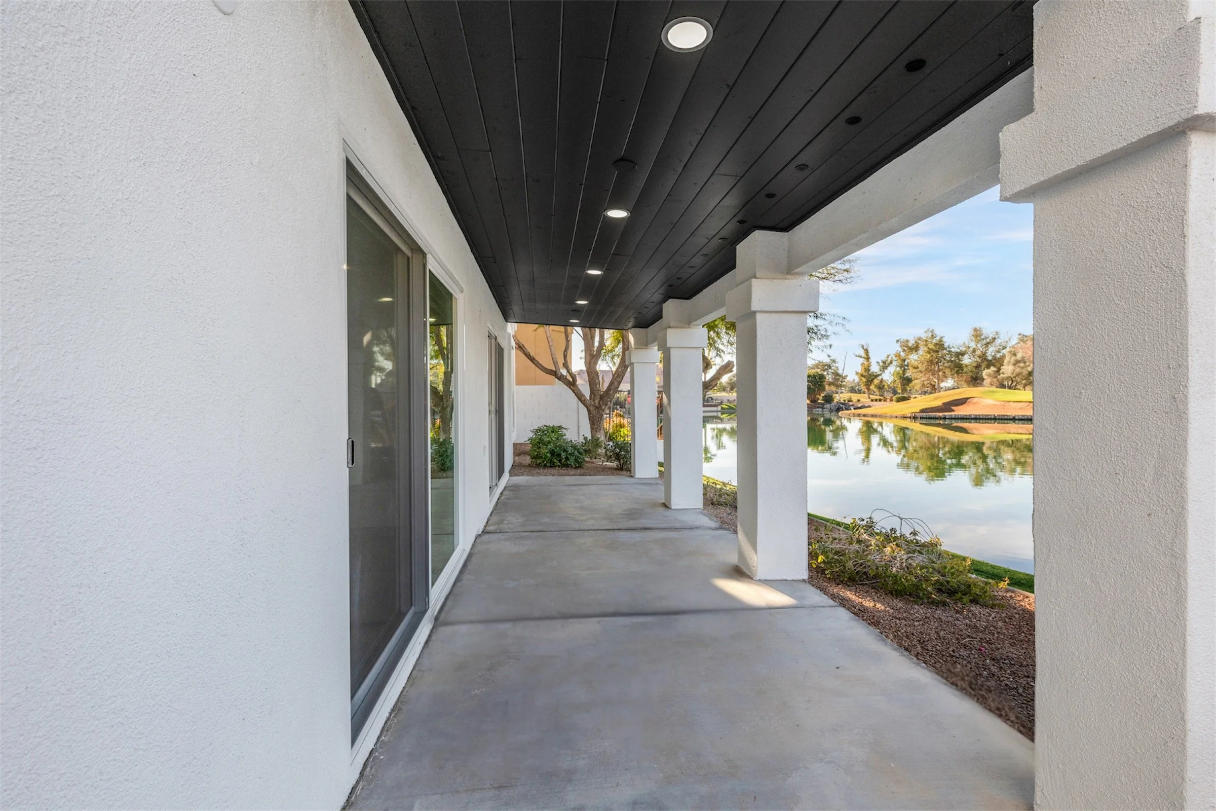 This covered patio overlooking a serene pool area in Chandler, AZ highlights the beauty of real estate photography with spacious outdoor living and tranquil views.