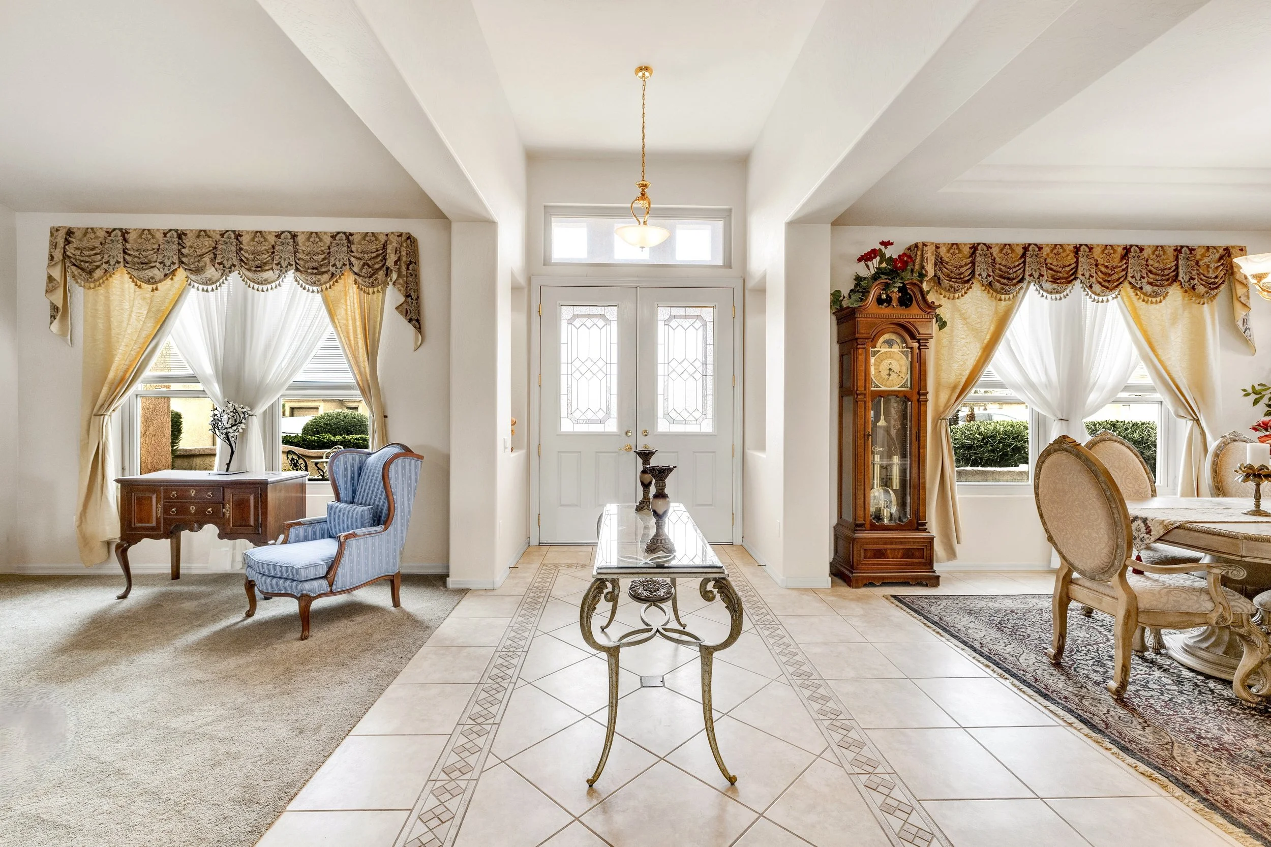 This bright entryway with elegant living and dining areas showcases exquisite design in Surprise, AZ, captured through professional real estate photography.