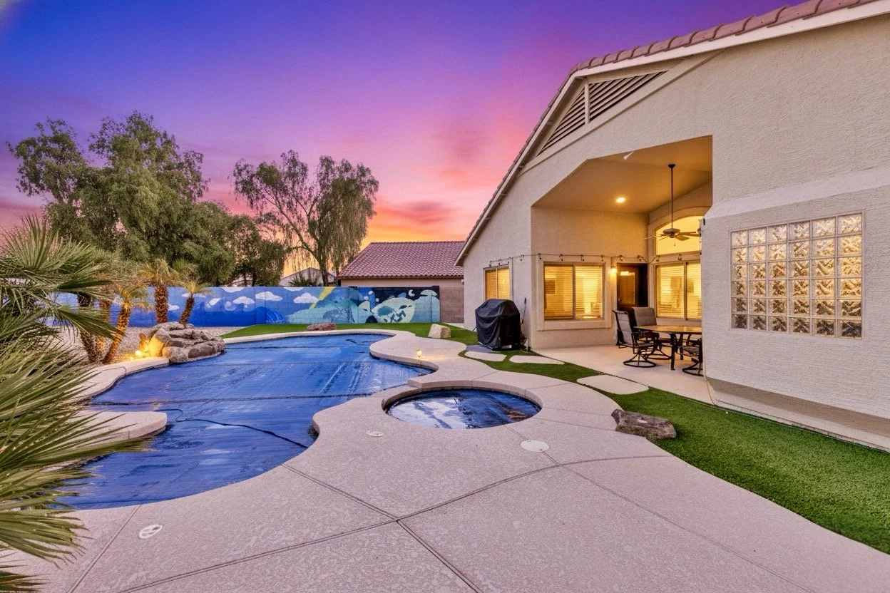 Beautiful twilight real estate photography showcasing a Phoenix, AZ backyard with a covered patio, pool, and vibrant sunset sky.