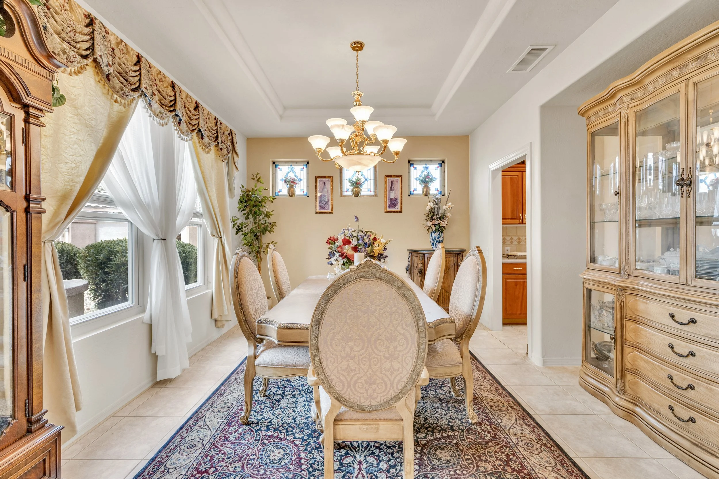 This traditional dining room features elegant furnishings and abundant natural light, perfectly captured by real estate photography in Surprise, AZ.