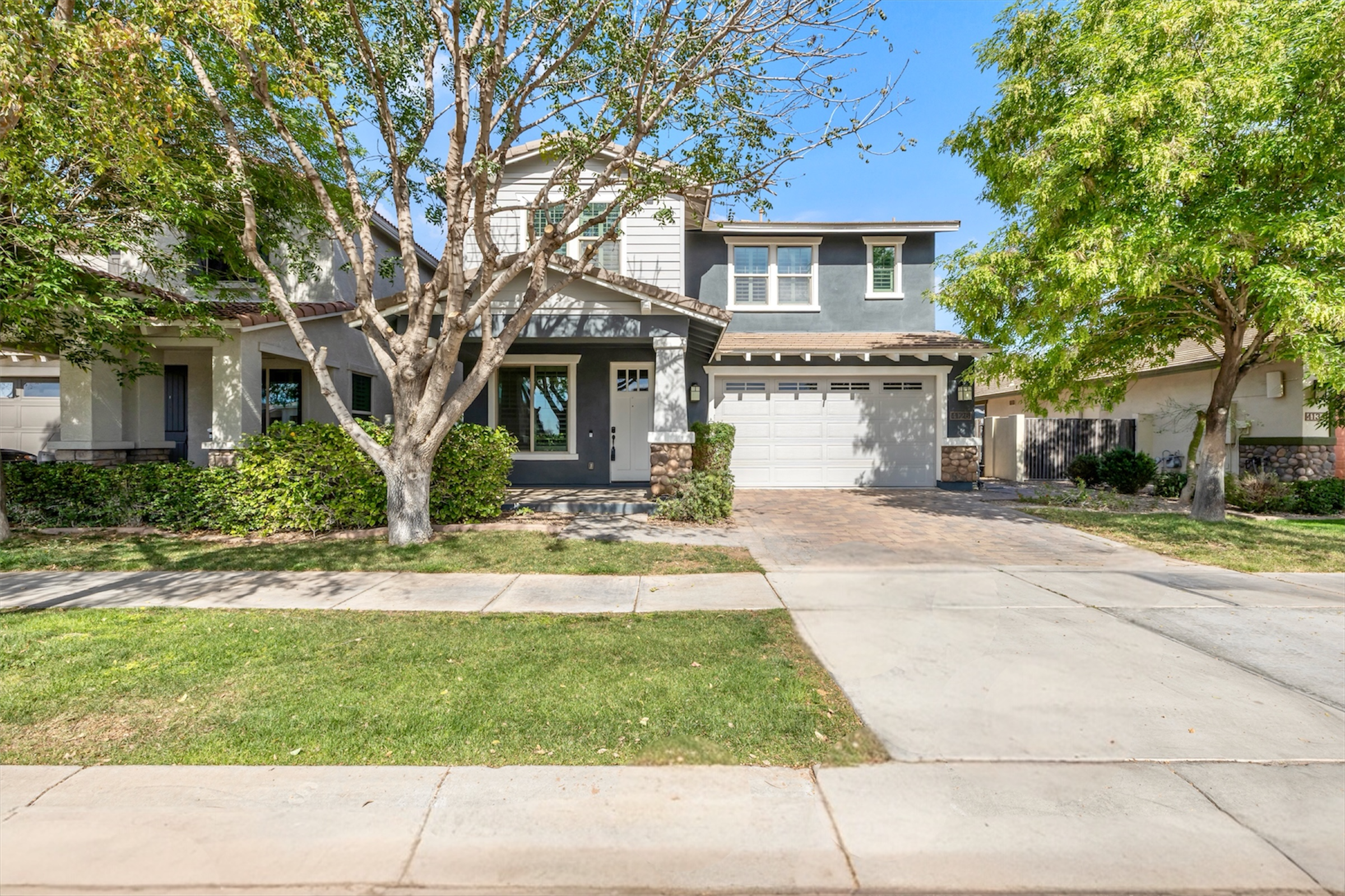 This charming two-story house in Gilbert, AZ showcases beautiful exterior design and landscaping, captured through expert real estate photography in Morrison Ranch neighborhood.