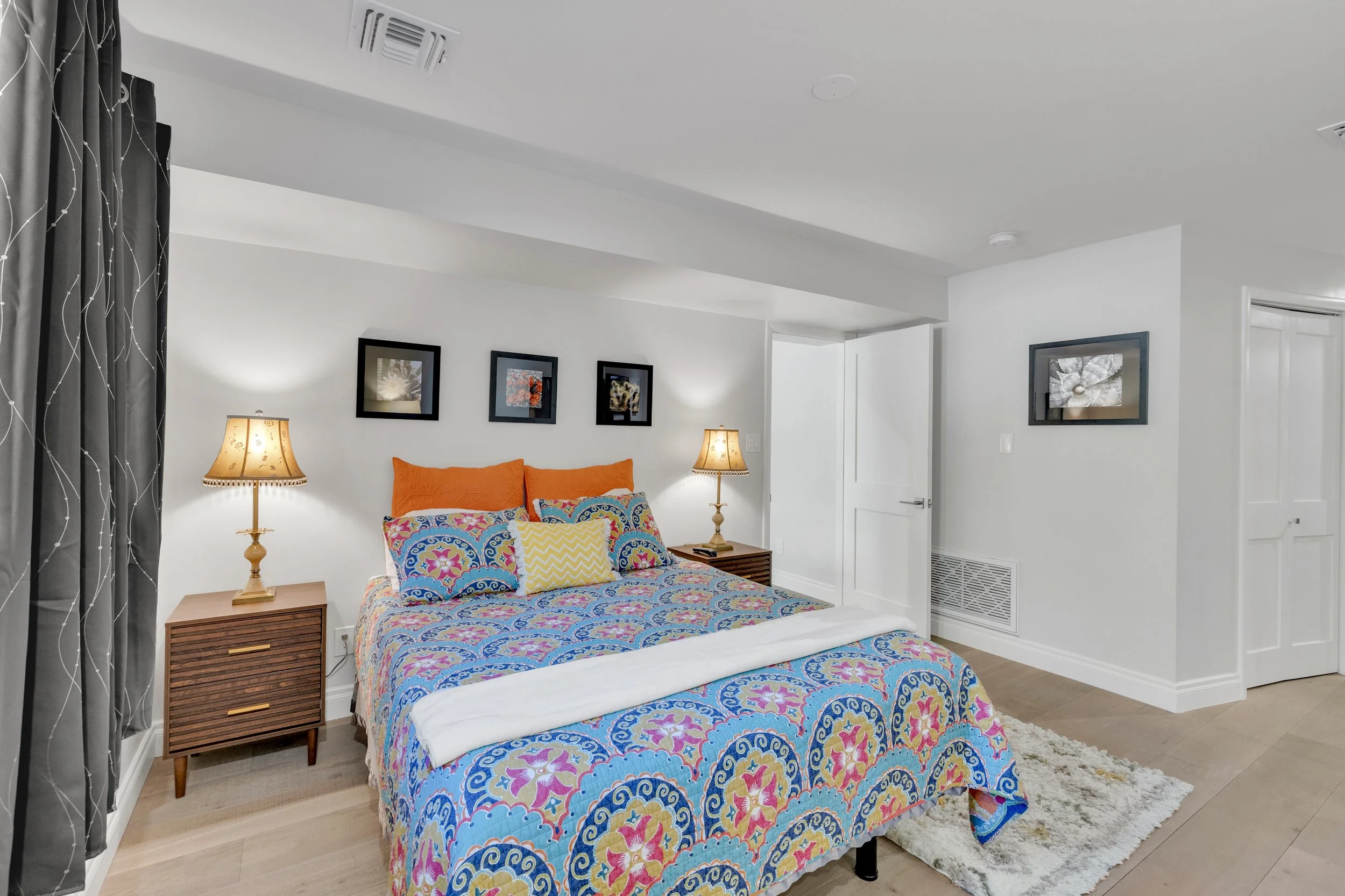 This bright bedroom in Paradise Valley, AZ features colorful bedding, modern lighting, and tasteful decor, captured with professional real estate photography to highlight the room's inviting ambiance.