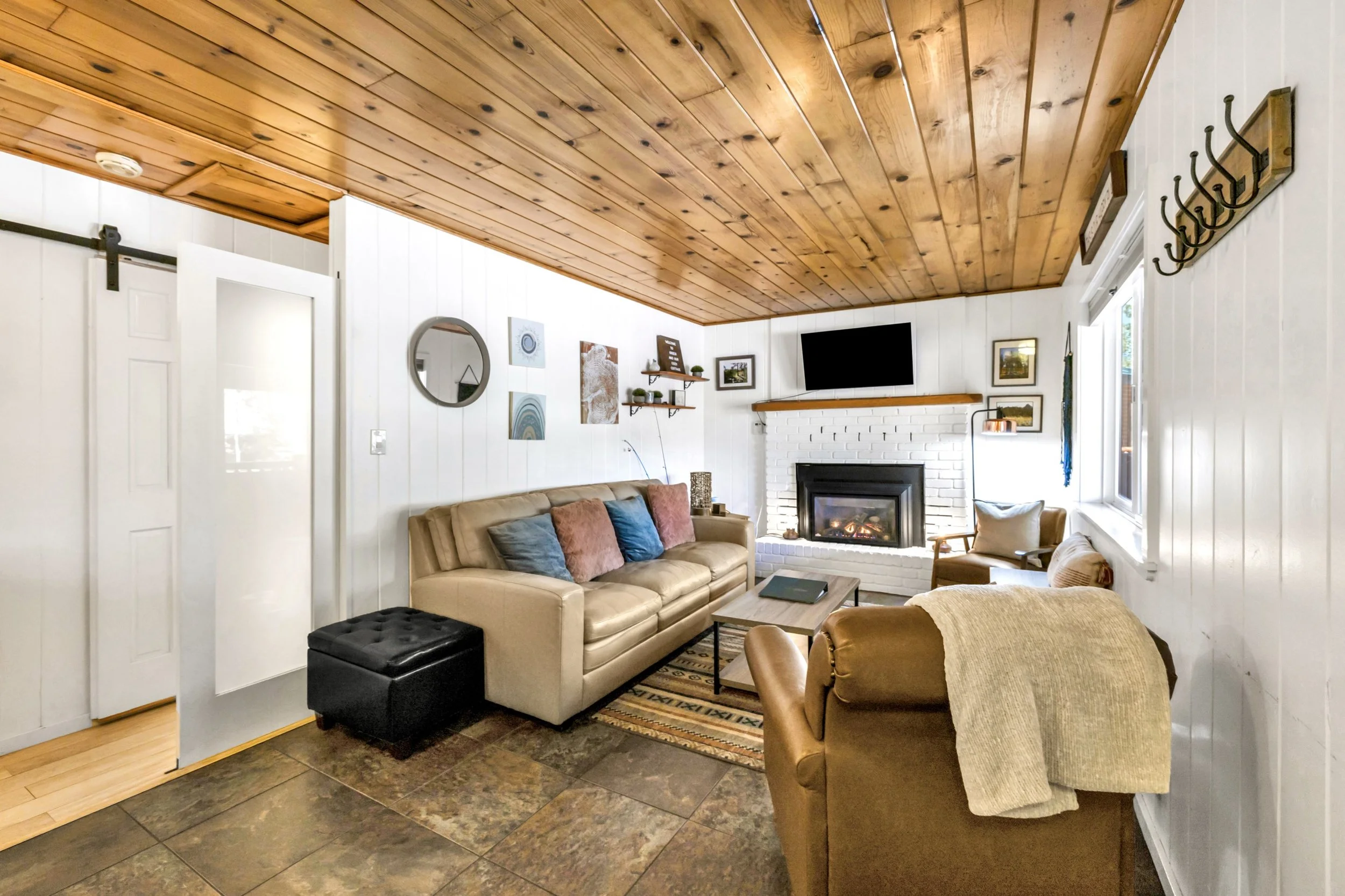 Beautiful cozy living room with a fireplace and wood ceiling in a Greer, AZ home, captured with professional real estate photography.