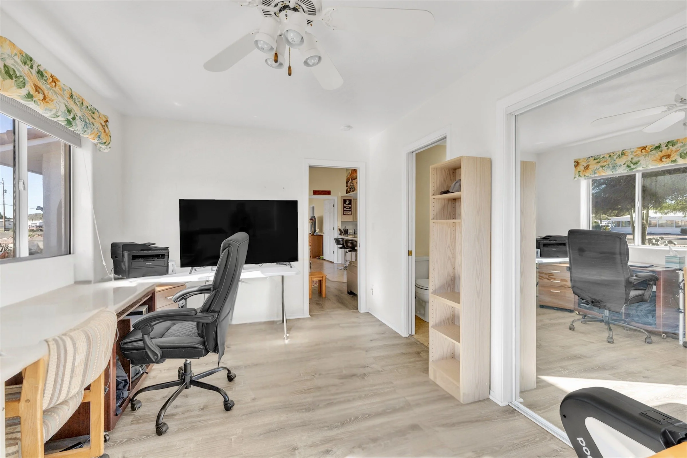 Bright home office with large windows and wood flooring showcased in Queen Valley, AZ, captured with professional real estate photography highlighting natural light and spacious layout.