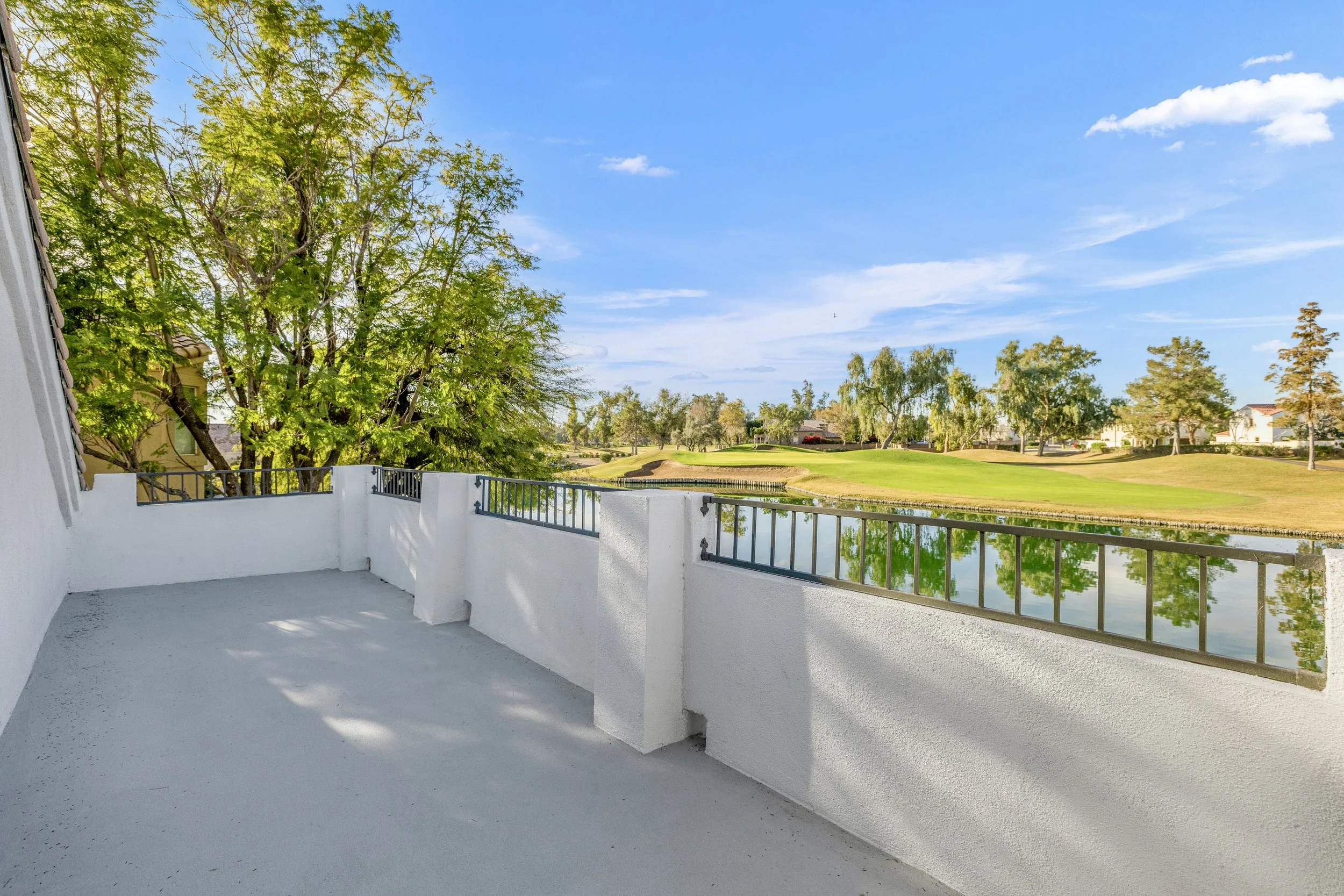 This balcony with water and golf course views showcases the beauty of Chandler, AZ through expert real estate photography, highlighting outdoor living potential.