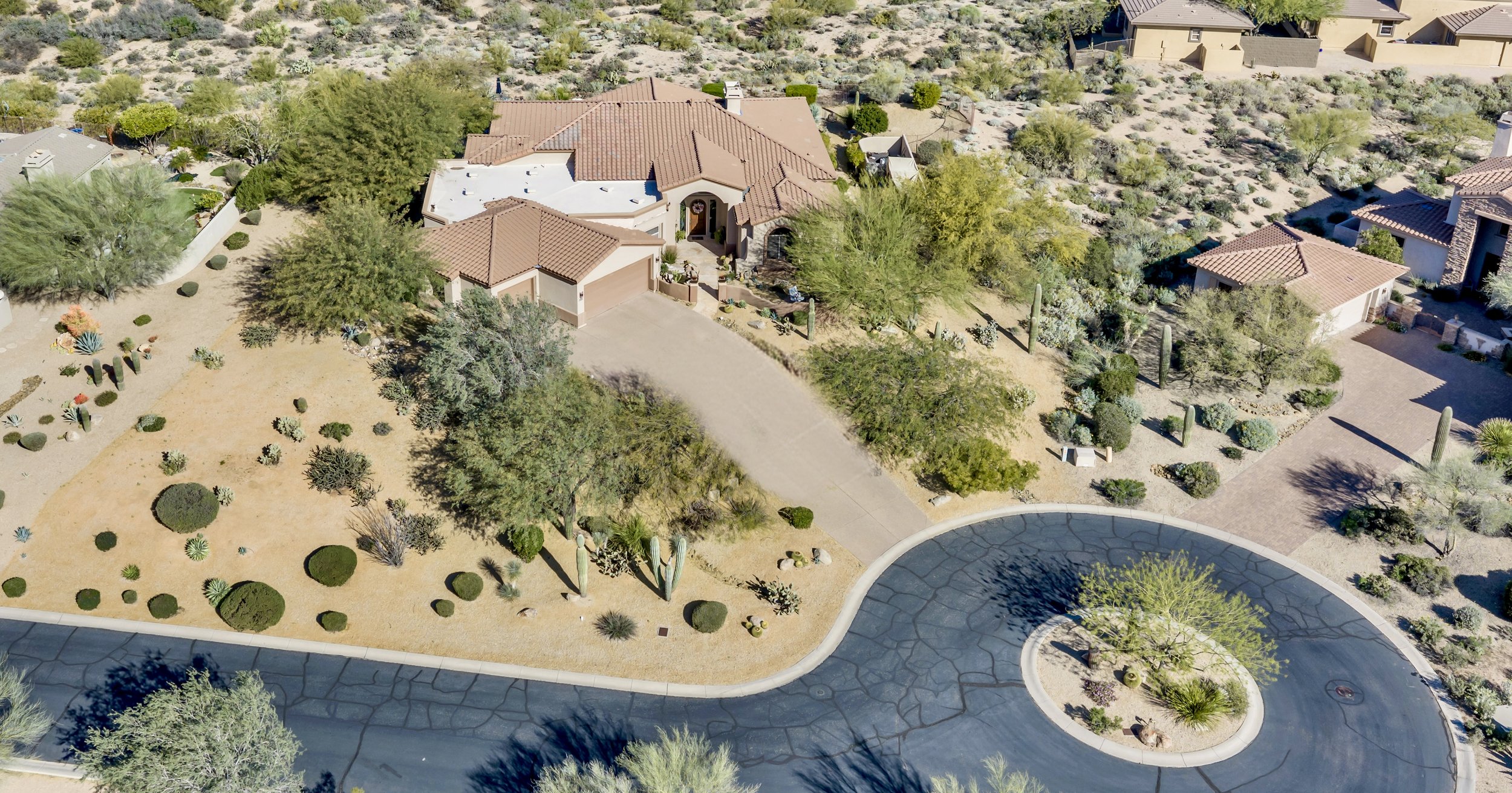 A stunning aerial view of a desert-landscaped home in Scottsdale, AZ, showcasing beautiful natural surroundings and expert real estate photography capturing this unique property on E Lofty Point Rd.