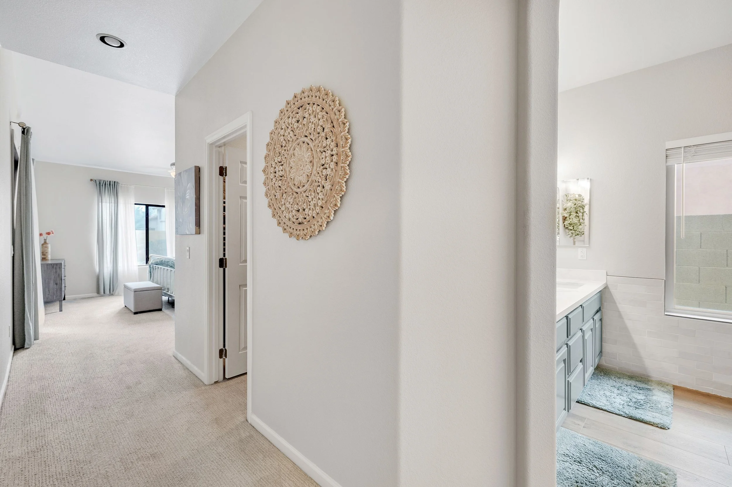 Bright interior hallway showing a bedroom and bathroom with tasteful decor in Goodyear, AZ, captured with professional real estate photography.