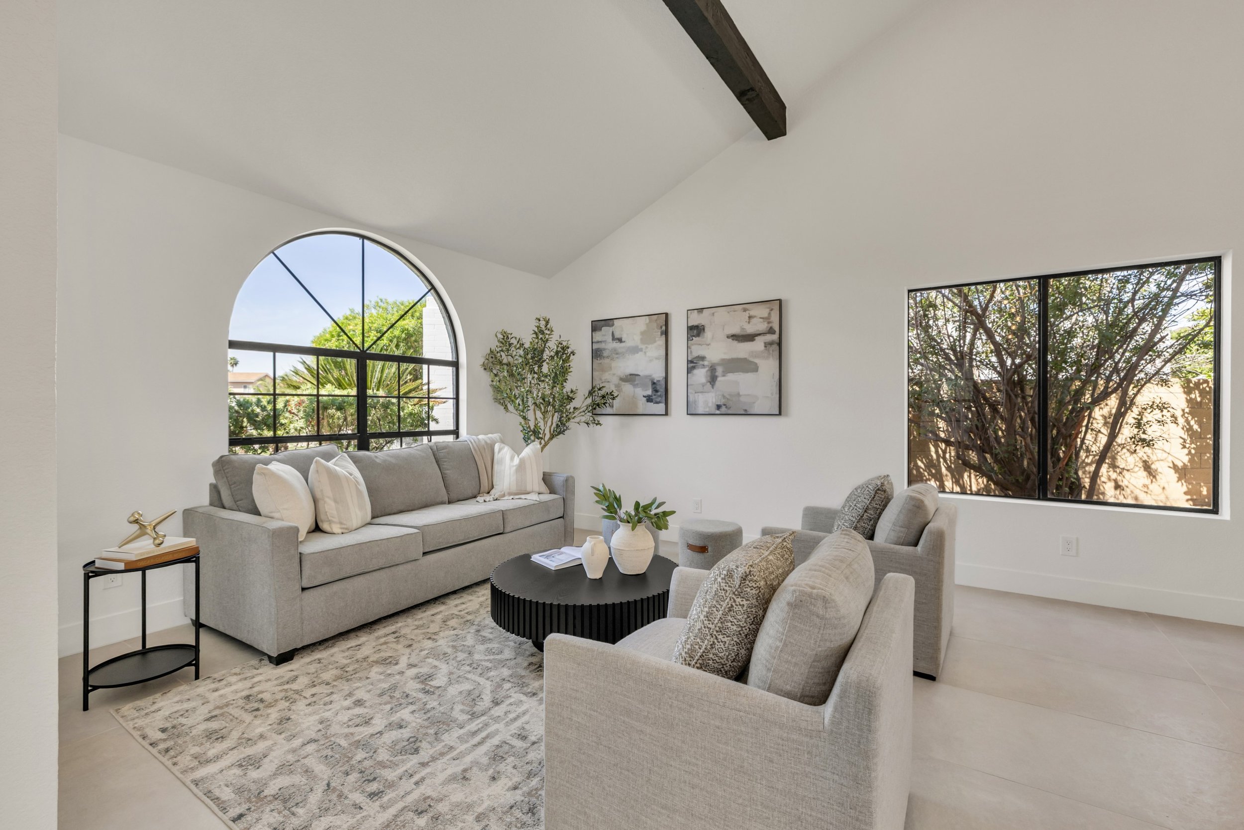 This bright living room in Scottsdale, AZ features modern gray furniture and large windows, captured perfectly with professional real estate photography.