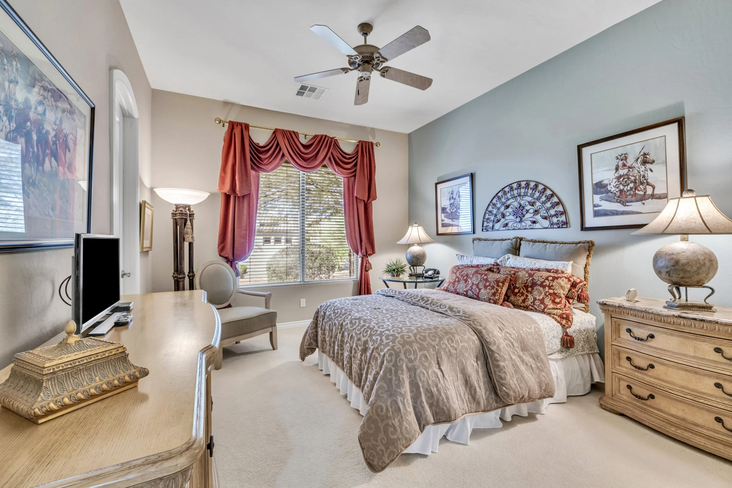 This beautifully decorated bedroom with natural light in Scottsdale, AZ, highlights elegant furnishings and unique decor, perfect for real estate photography showcasing comfort and style.
