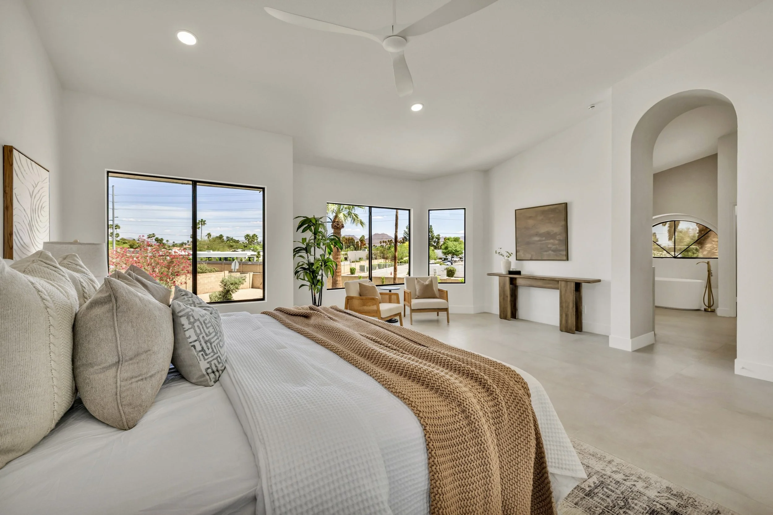 This spacious bedroom with large windows offers stunning views and natural light, showcasing modern real estate photography in Scottsdale, AZ.