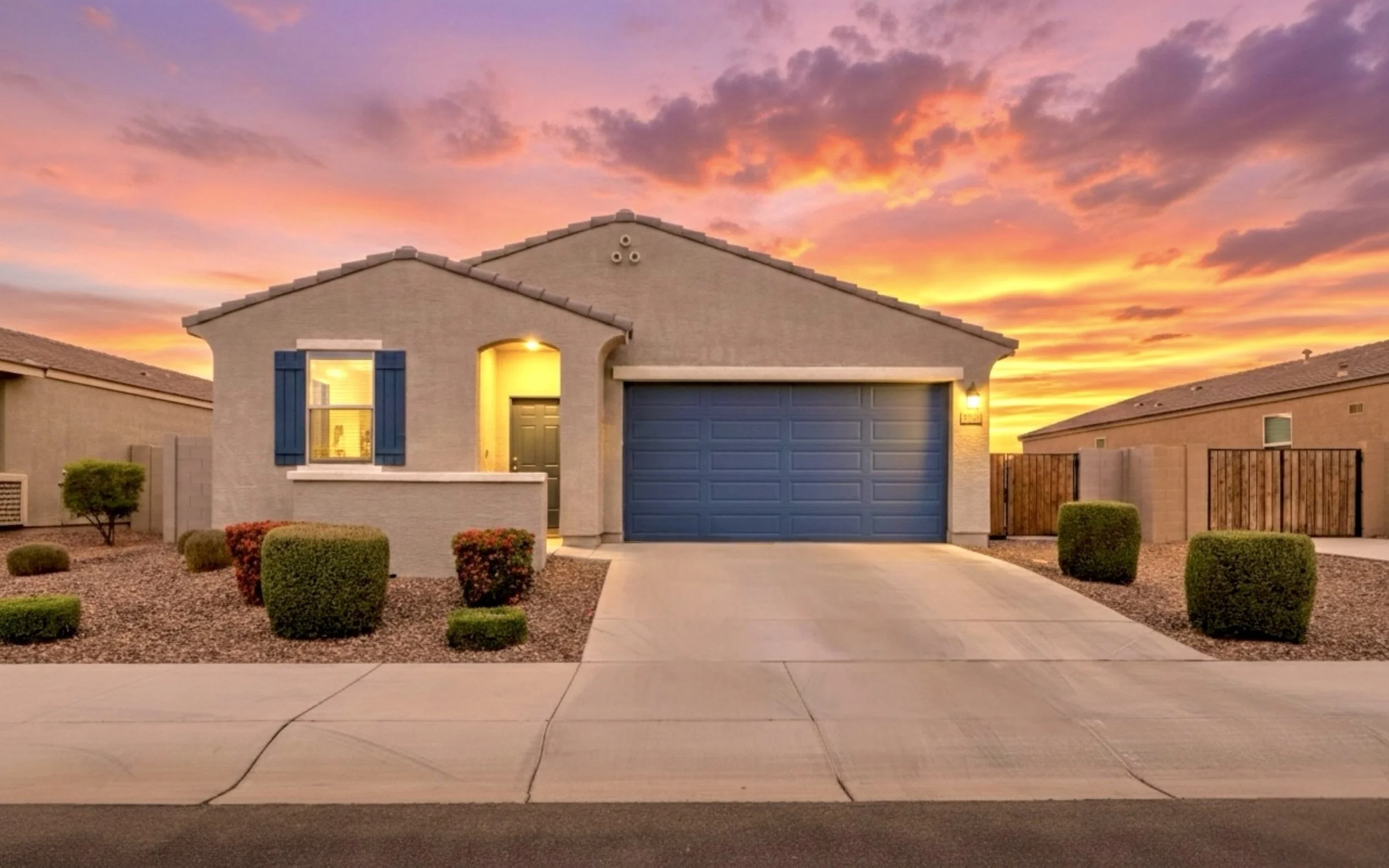 Stunning real estate photography of a suburban home at sunset in San Tan Valley, AZ, featuring a beautifully lit exterior and vibrant sky colors that highlight the property's curb appeal.