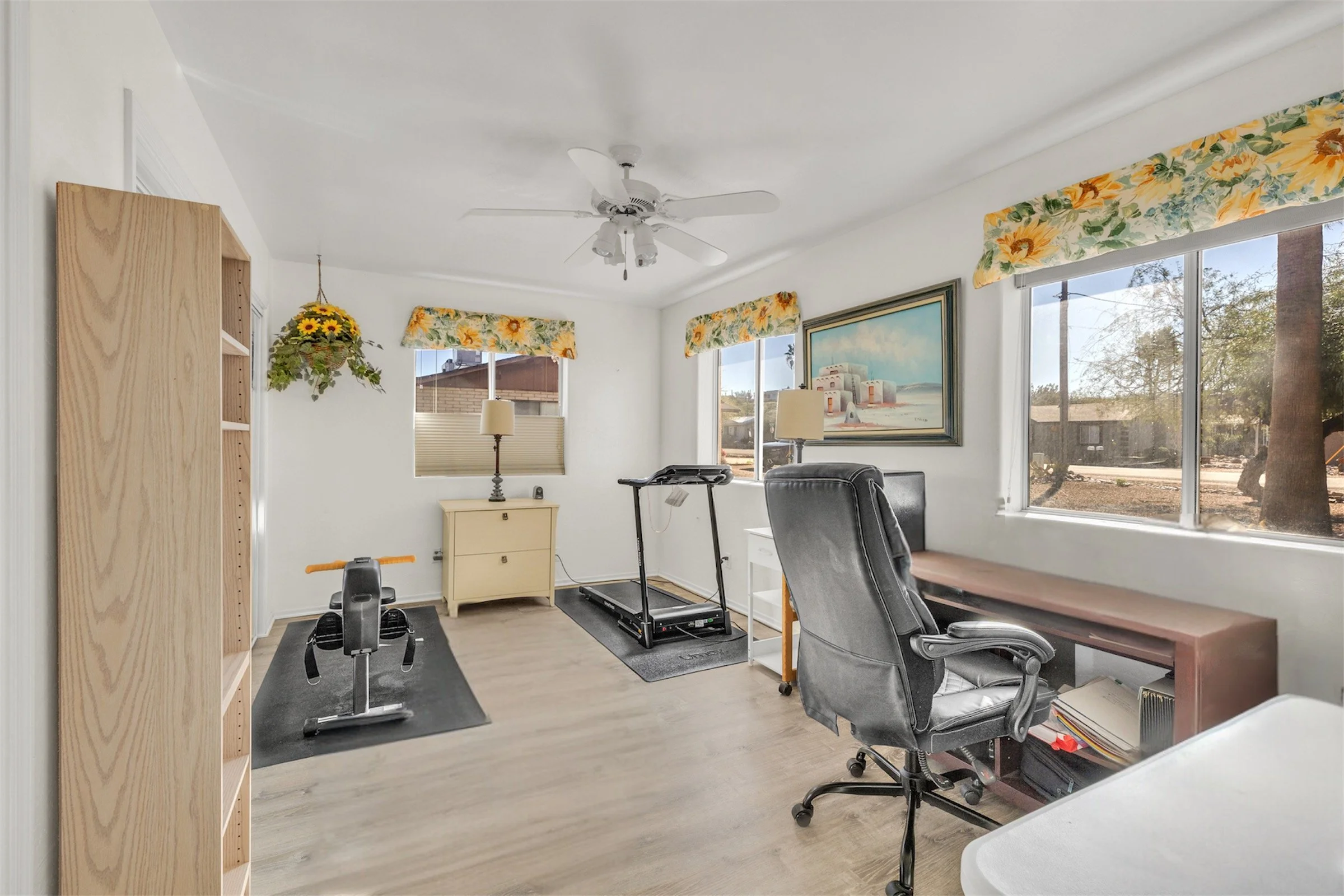 This bright home office with gym equipment is showcased through expert real estate photography in Queen Valley, AZ, highlighting a versatile and inviting space filled with natural light.