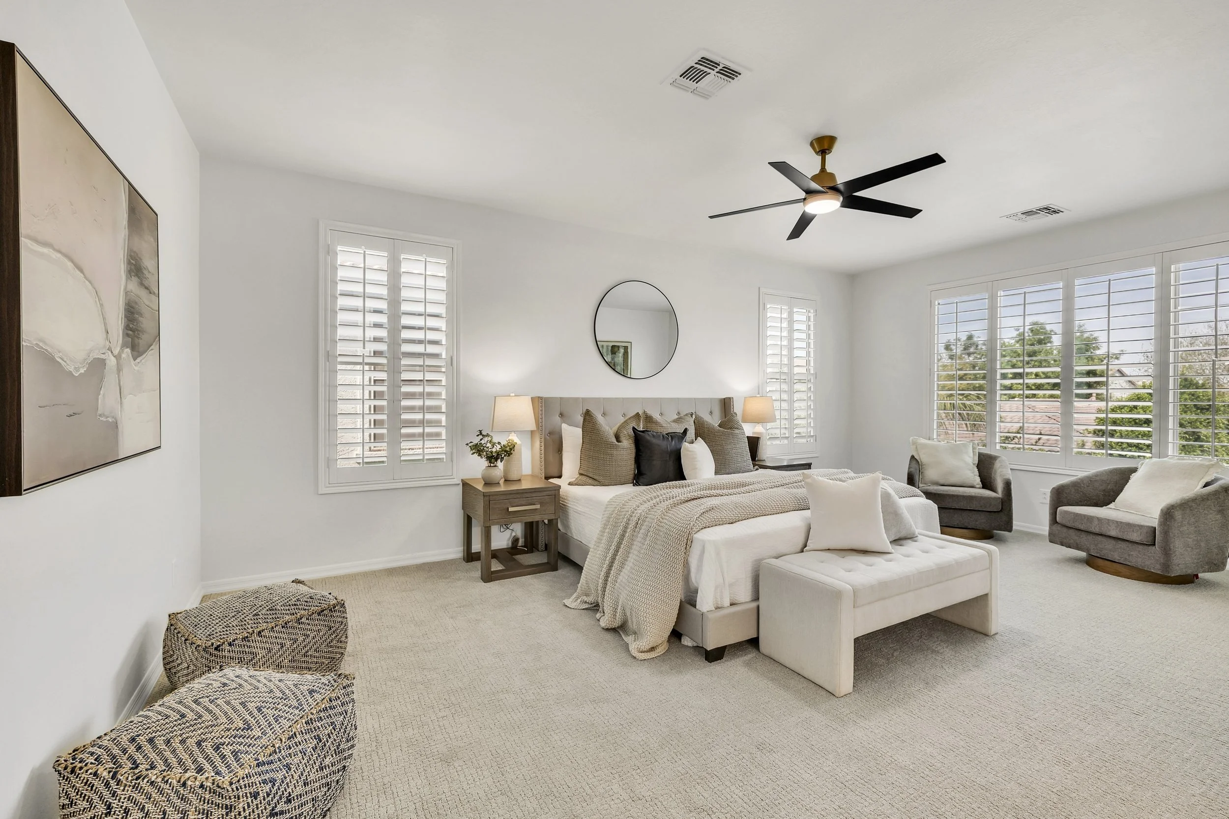 Bright and spacious bedroom with large windows and modern ceiling fan in a Gilbert, AZ home captured with real estate photography.