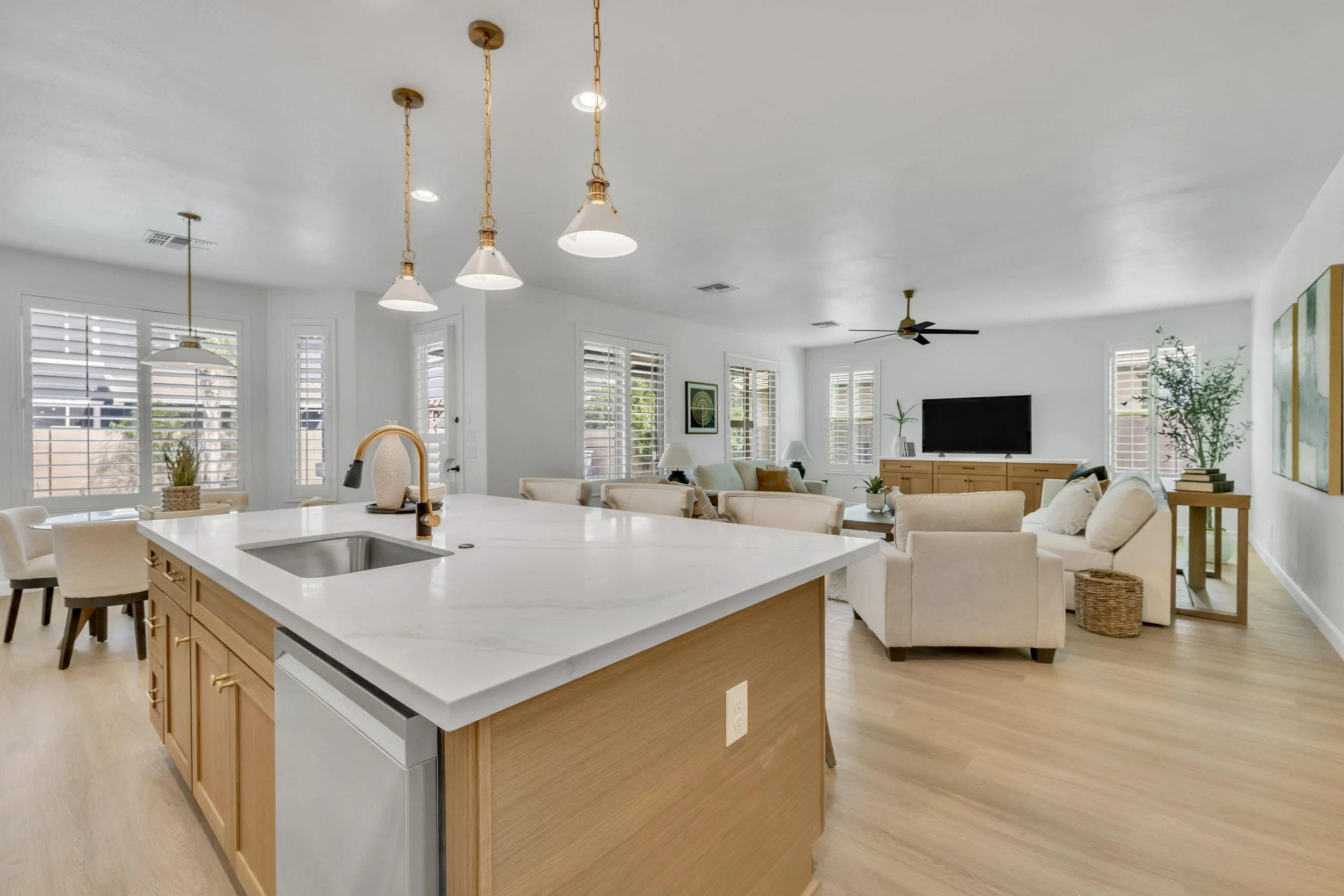 This bright open-concept kitchen and living room showcase modern design and ample natural light in a stylish home in Gilbert, AZ, captured with professional real estate photography.