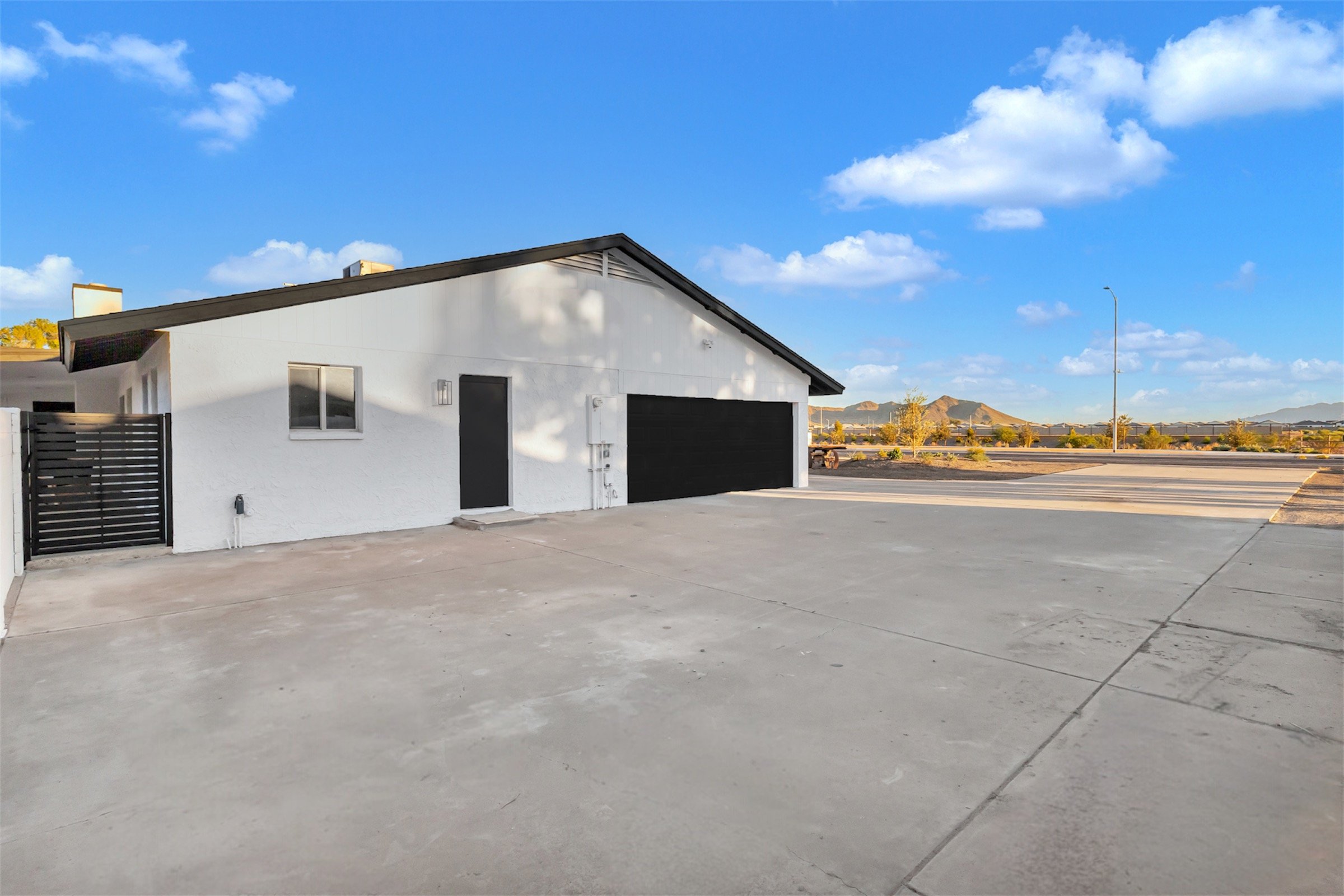 Wide driveway and side-entry garage with mountain views at a renovated home in Phoenix, AZ.