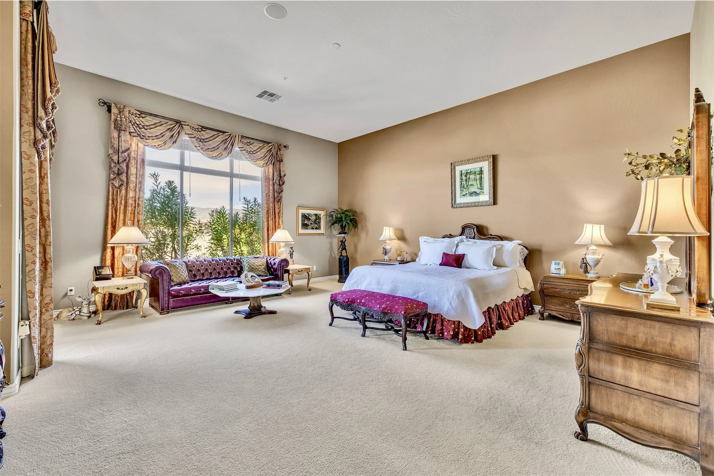 Bright and spacious bedroom with large window showcasing elegant furnishings and traditional decor in Scottsdale, AZ, captured through professional real estate photography.