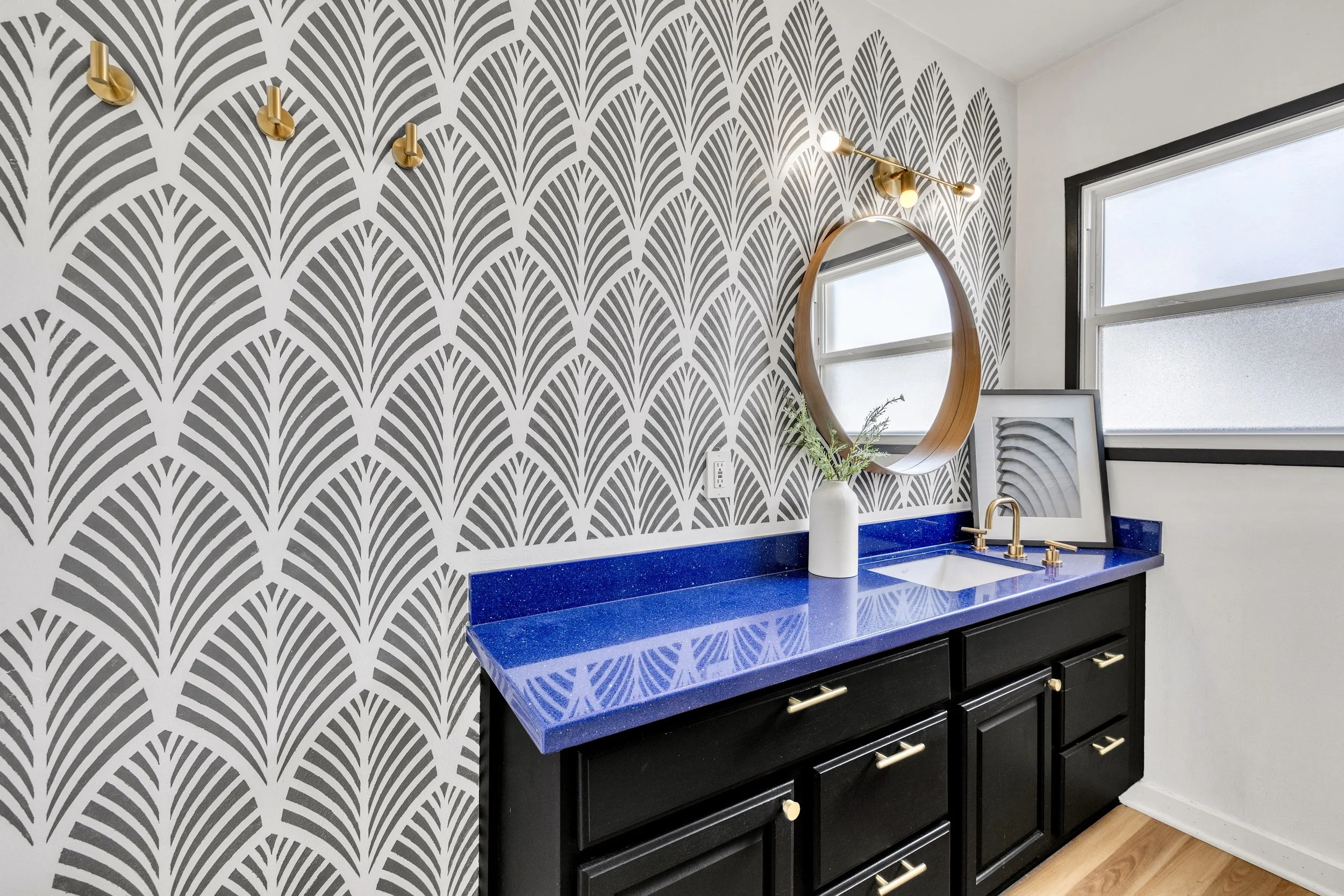 This modern bathroom vanity features a striking blue countertop and patterned wall, captured with expert real estate photography in Phoenix, AZ.