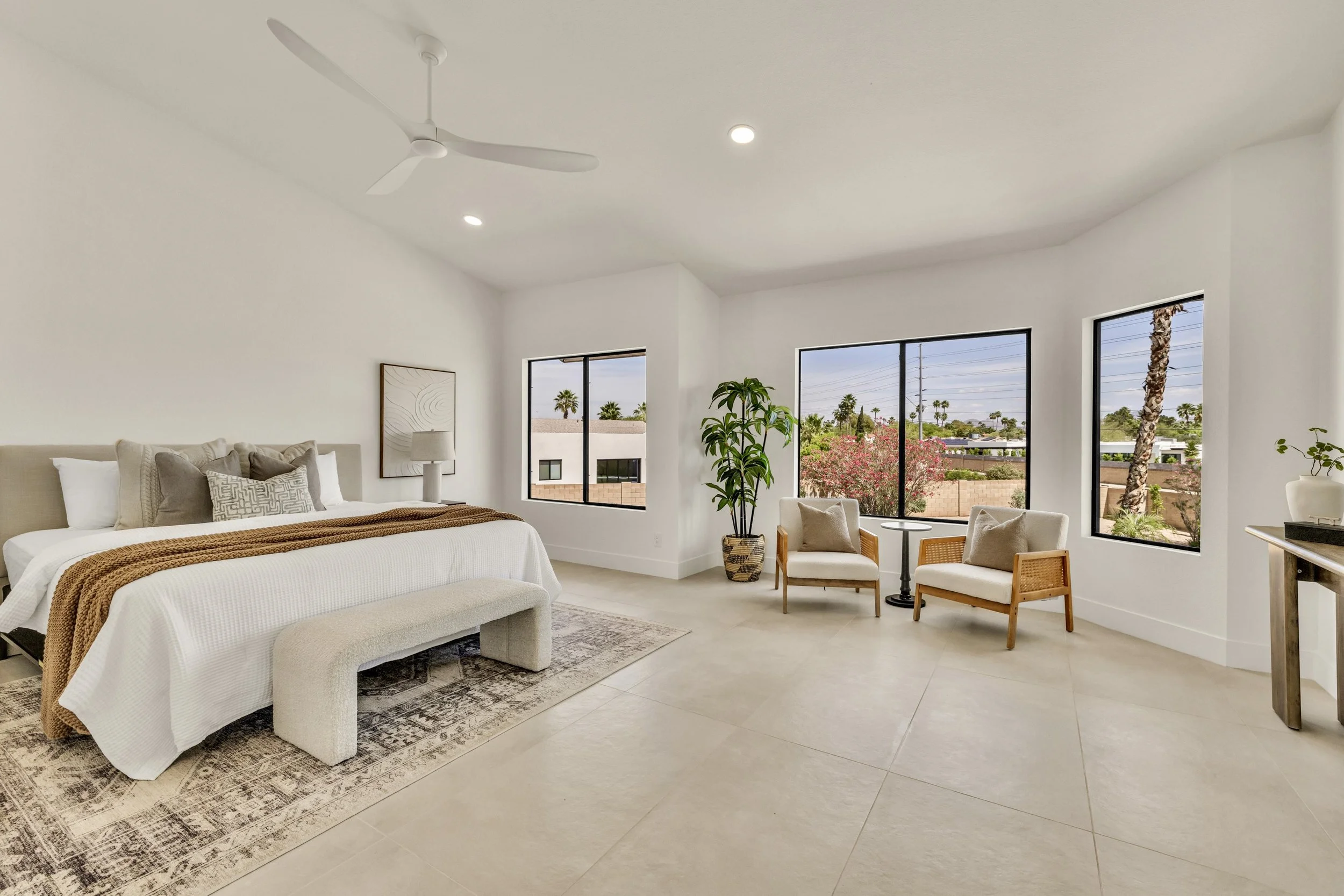 This spacious bedroom in Scottsdale, AZ features large windows, modern neutral decor, and excellent natural lighting, captured expertly in real estate photography.