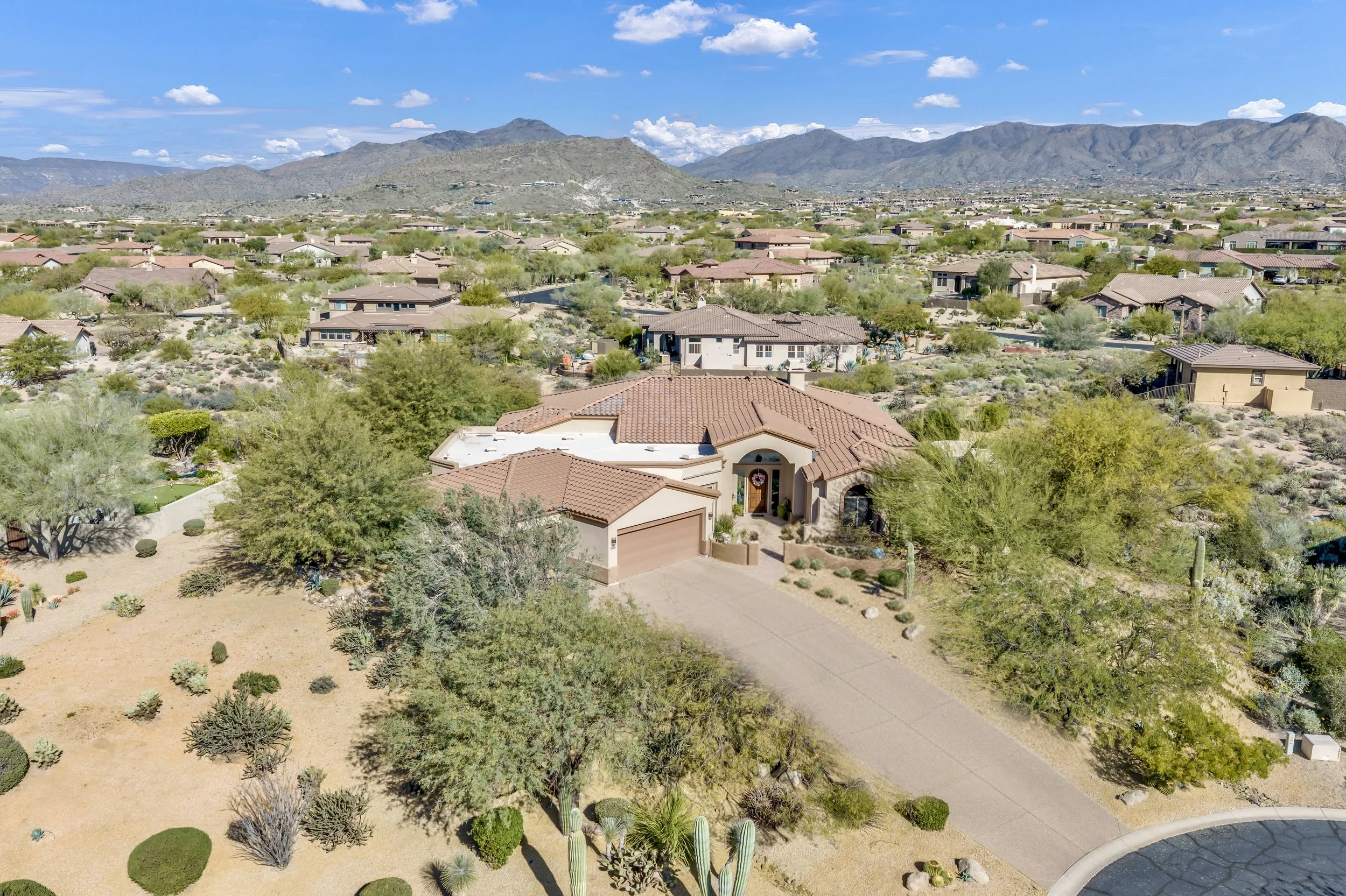 Aerial real estate photography capturing homes with desert landscaping and mountain views in Scottsdale, AZ, showcasing the beauty of the community and its natural surroundings.