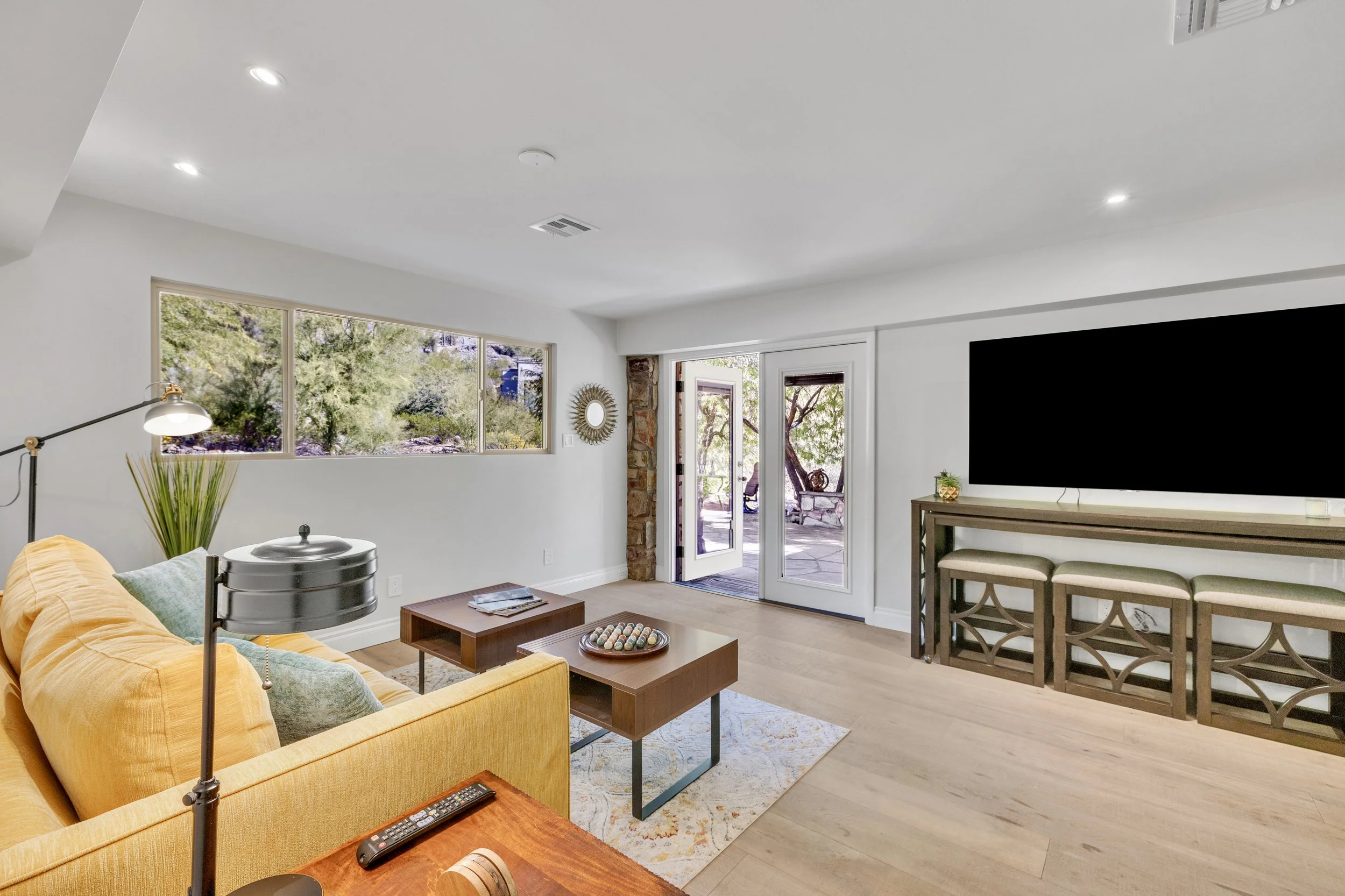 Bright living room interior with a yellow couch and natural light, showcasing a modern space in Paradise Valley, AZ, captured with professional real estate photography.