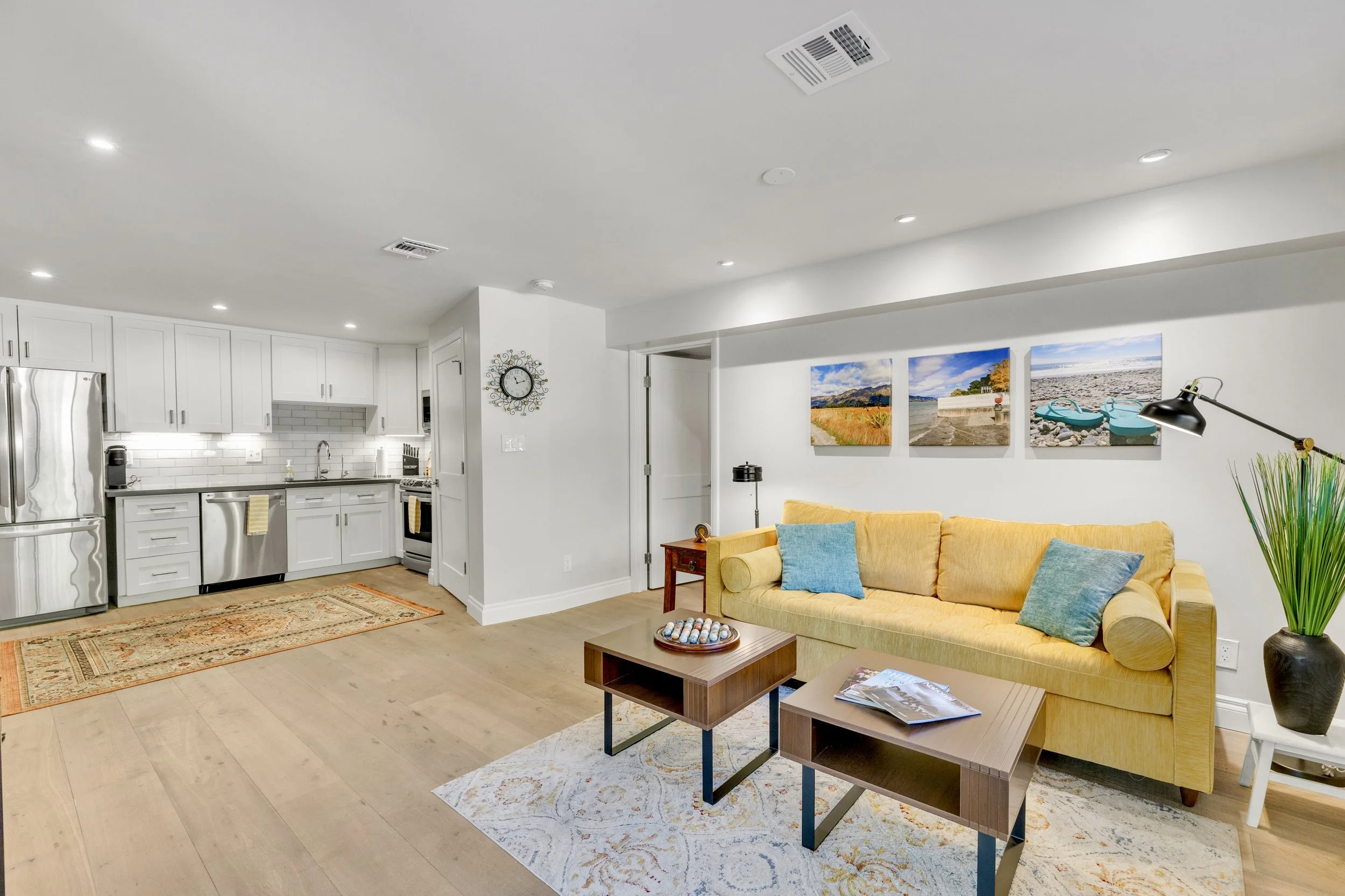 This modern living room and kitchen interior in Paradise Valley, AZ showcases bright, stylish design with ample lighting and contemporary furnishings, perfect for real estate photography.