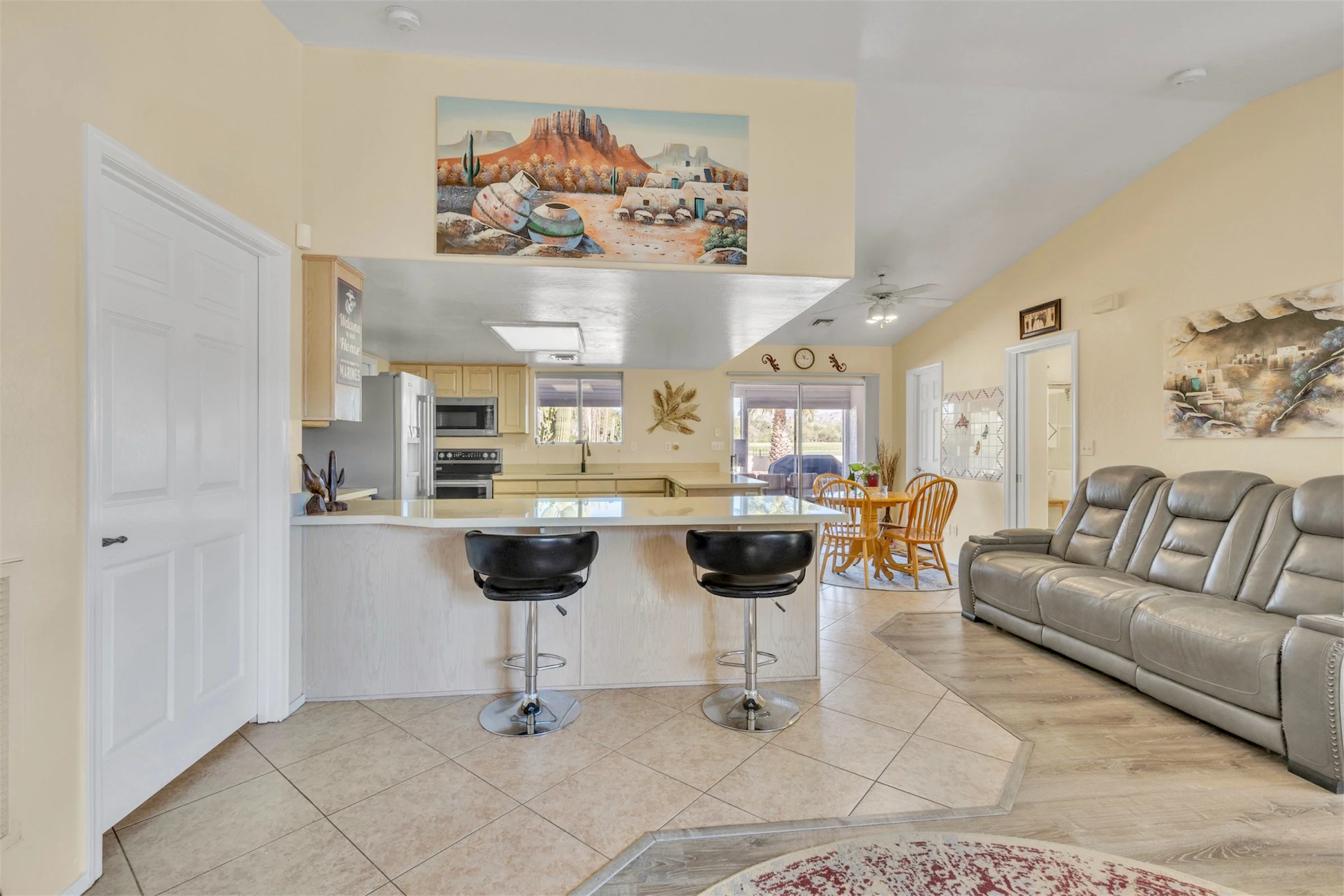 This spacious open kitchen and living room feature ample seating and natural light, showcased through professional real estate photography in Queen Valley, AZ.