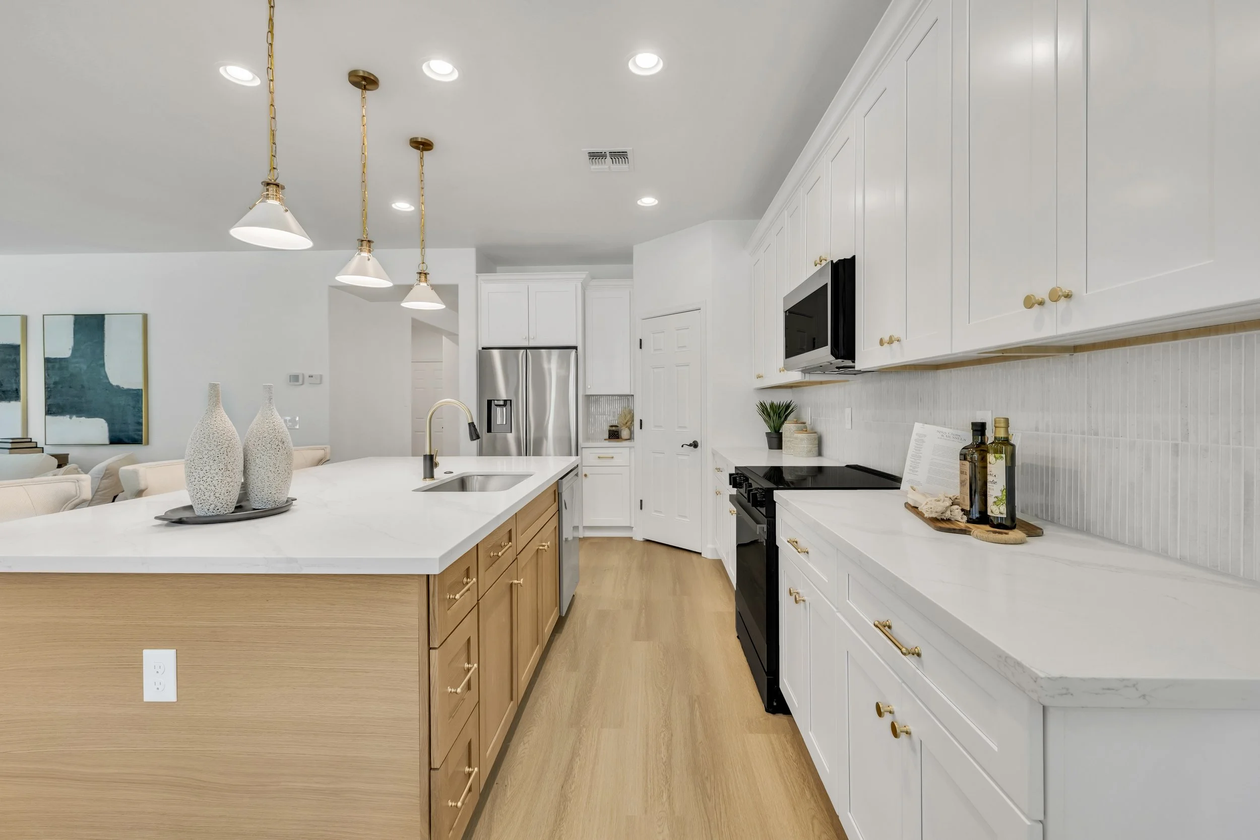 Bright modern kitchen with white cabinetry and wood accents in a Gilbert, AZ home, featured in real estate photography in Morrison Ranch neighborhood.