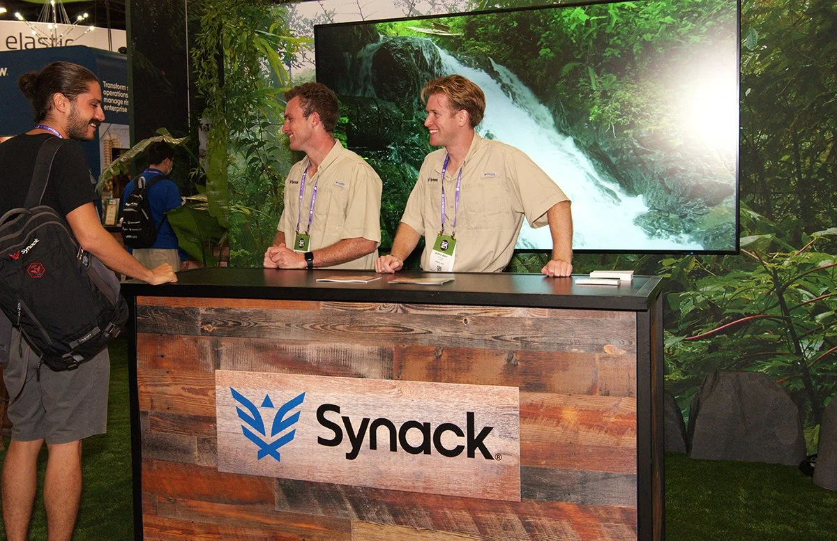 Registration desk with the waterfall video on the wall. The sound of the waterfall added a delightful feeling to the immersive experience.