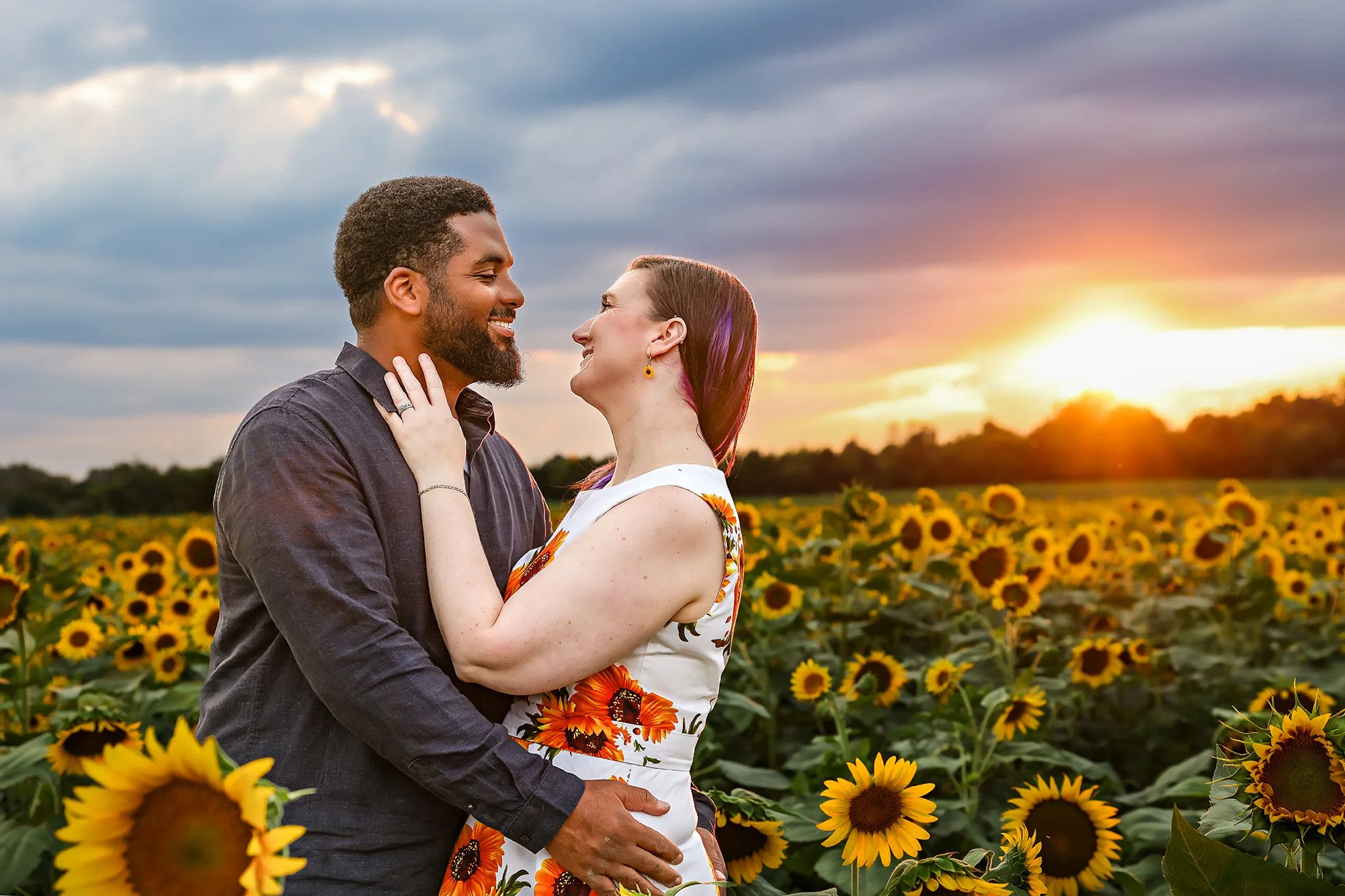  A couple looks lovingly into each other’s eyes in a field of sunflowers at Burnside Farms in Northern Virginia during their Northern Virginia Photography session 