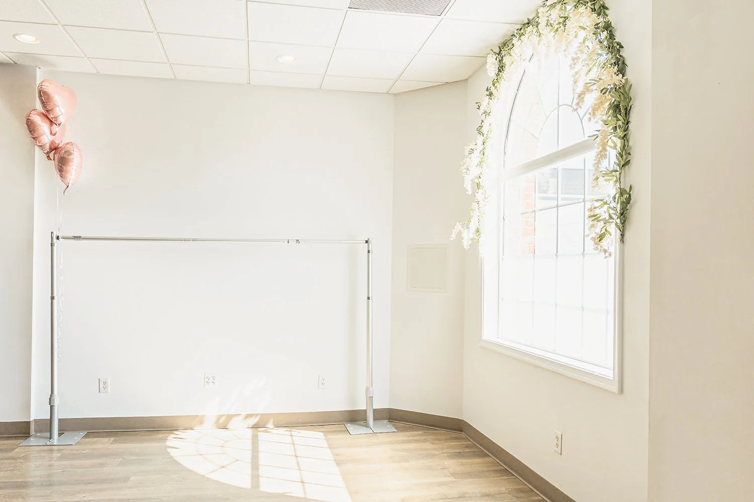 A beautiful arch window with wisteria hanging from it in the studio of Worthy of Love Photography in Front Royal, VA