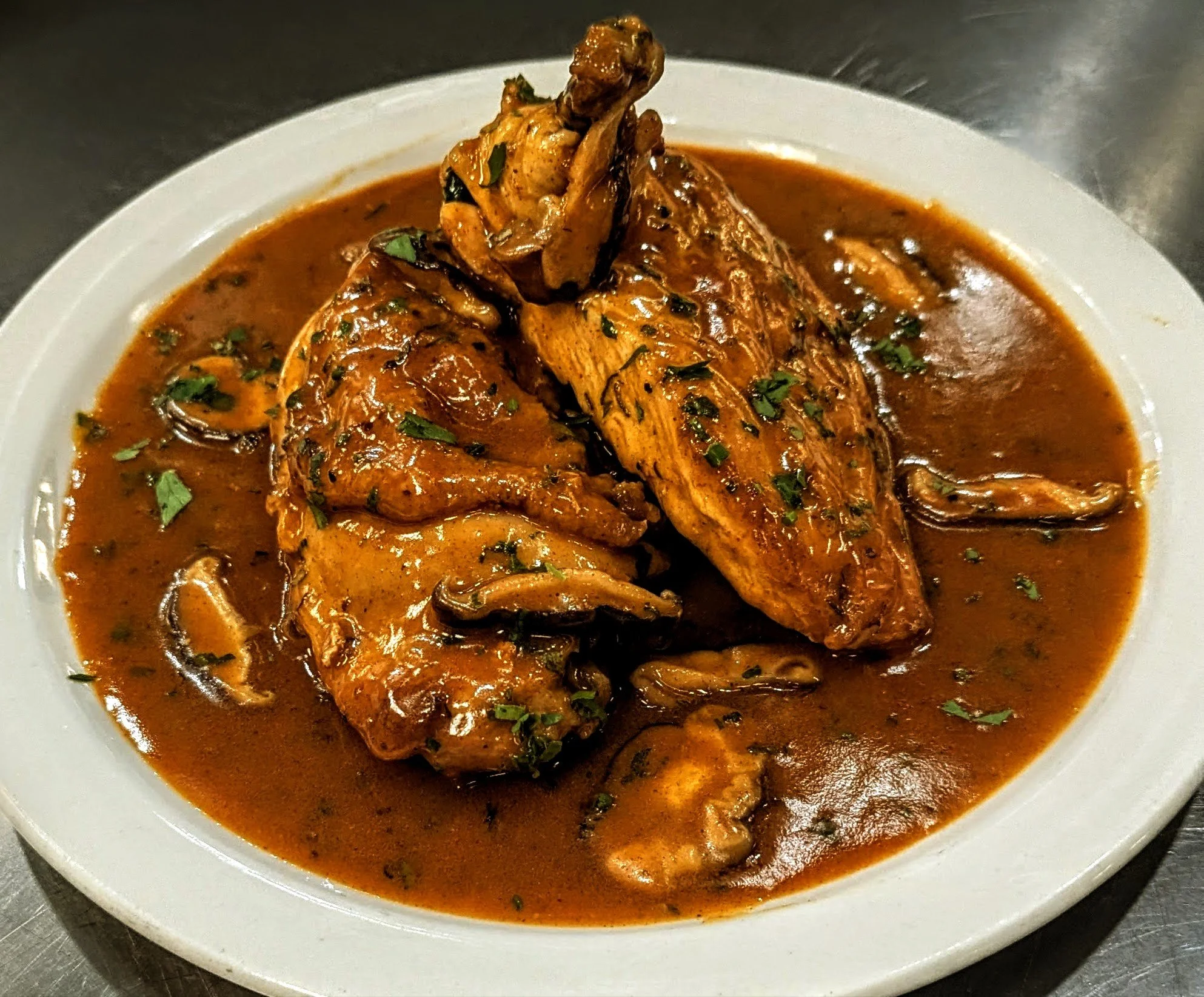 Half chicken paprikash served over horseradish mashed potatoes with sautéed mushrooms, garnished with parsley and plated by private chef Alexander Cole in Tucson, Arizona