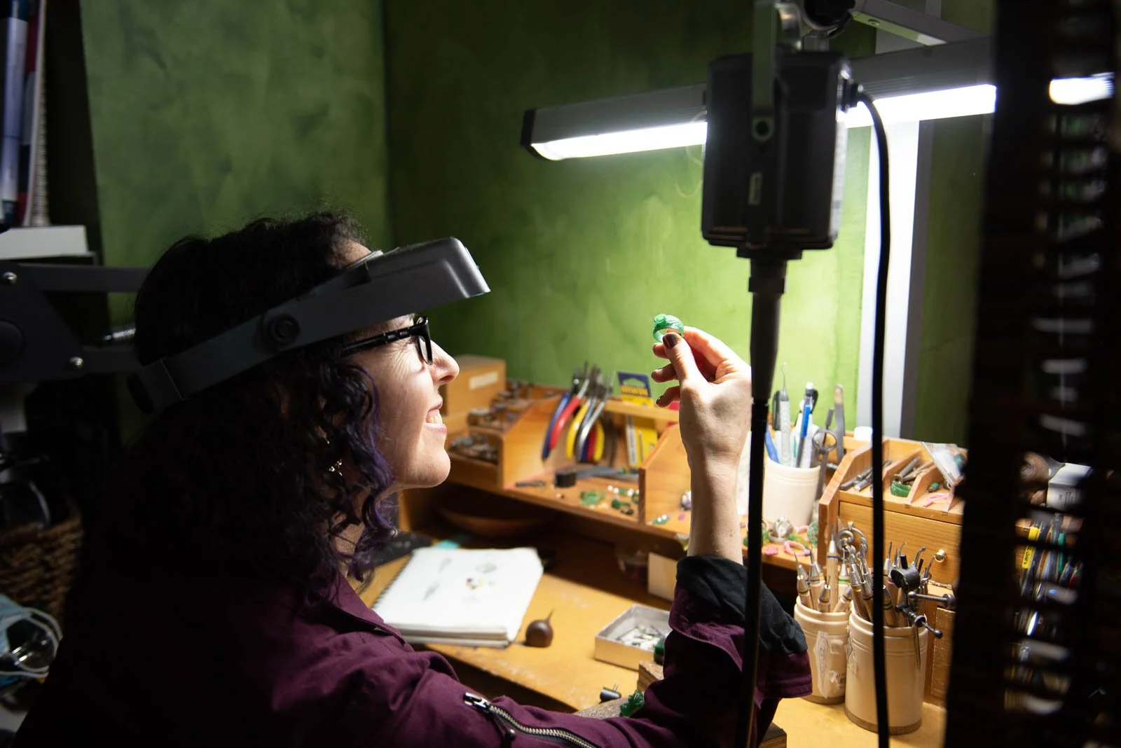 Jewelry artist working at bench with magnifier, small business photography Nova Scotia