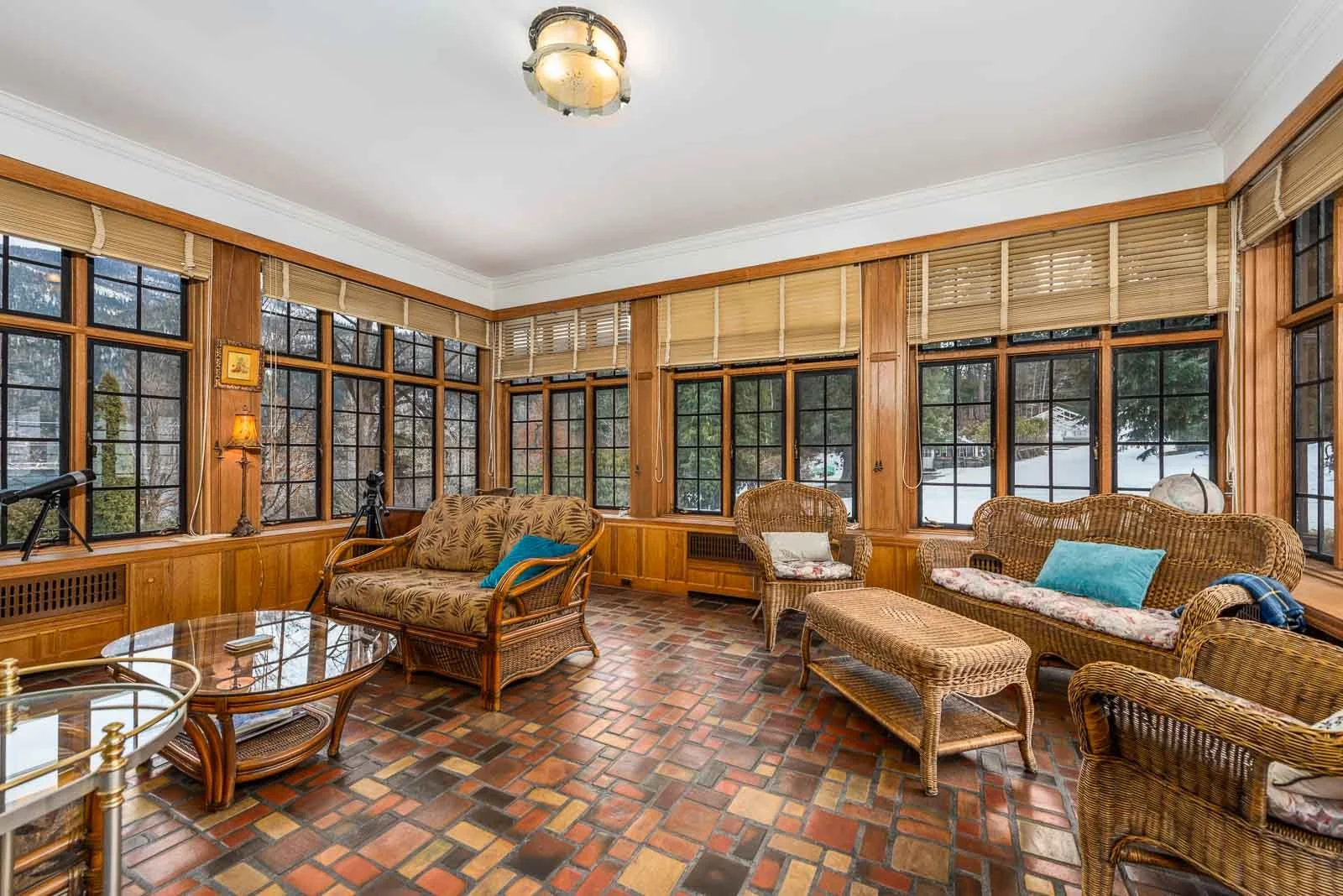 Rustic sunroom with brick flooring and wicker furniture, architectural photographer South Shore