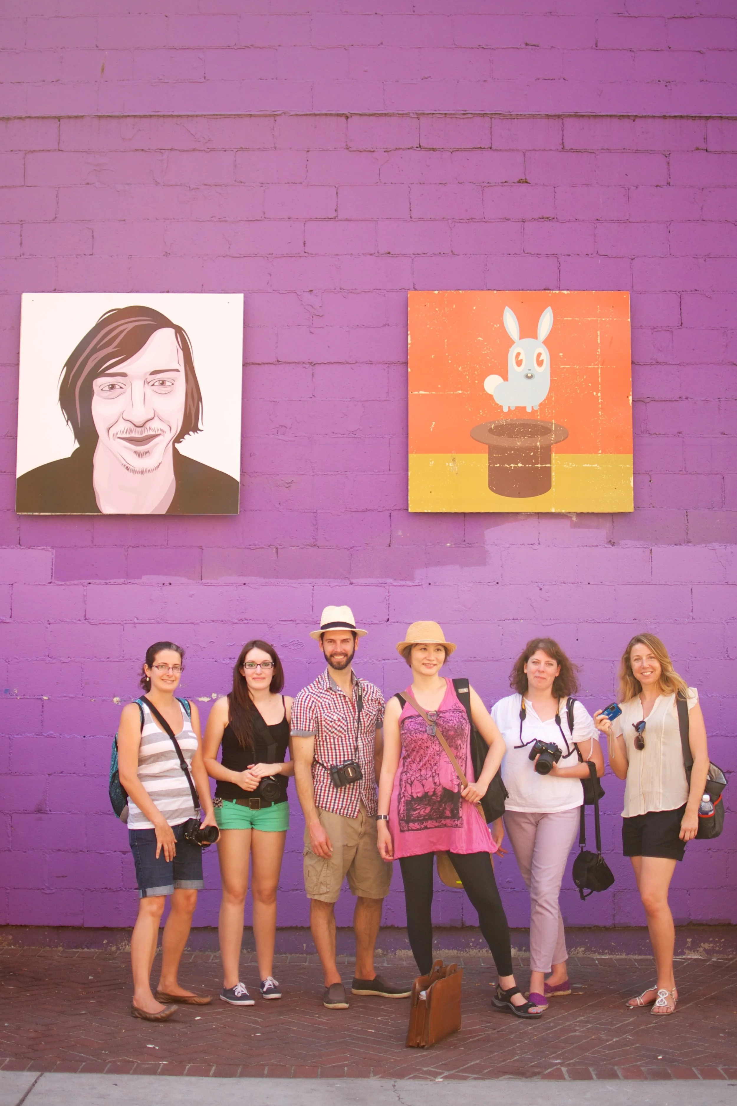Group of students posing in front of colourful mural wall - photography workshops nova scotia