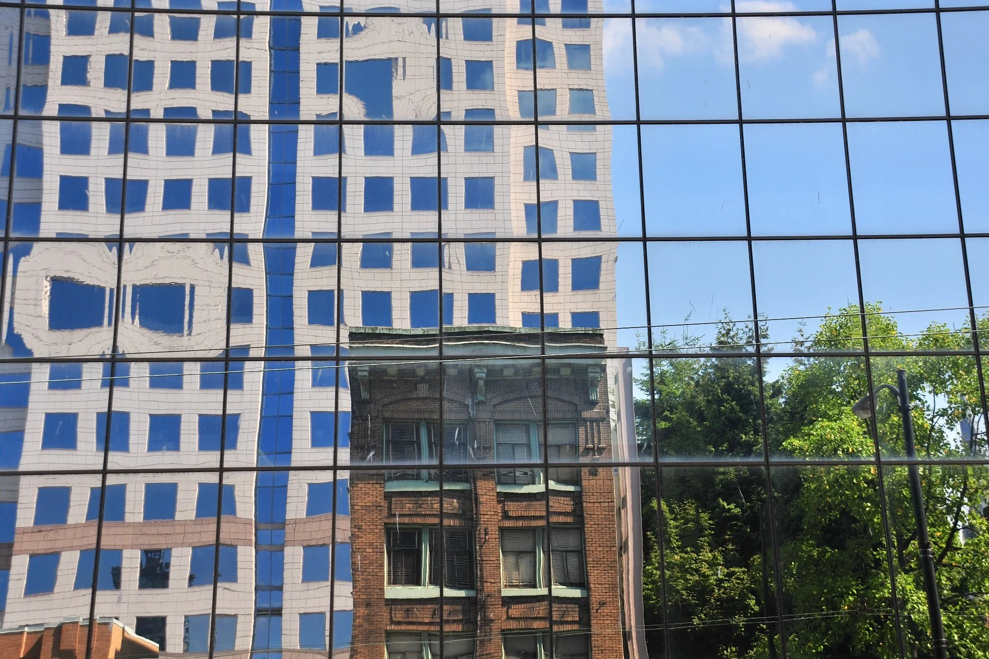 Reflection of buildings on glass facade captured in downtown Vancouver during photography tour