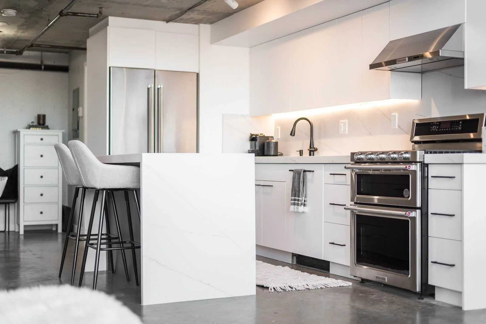 Modern white kitchen with island and bar stools, Nova Scotia interior design photography