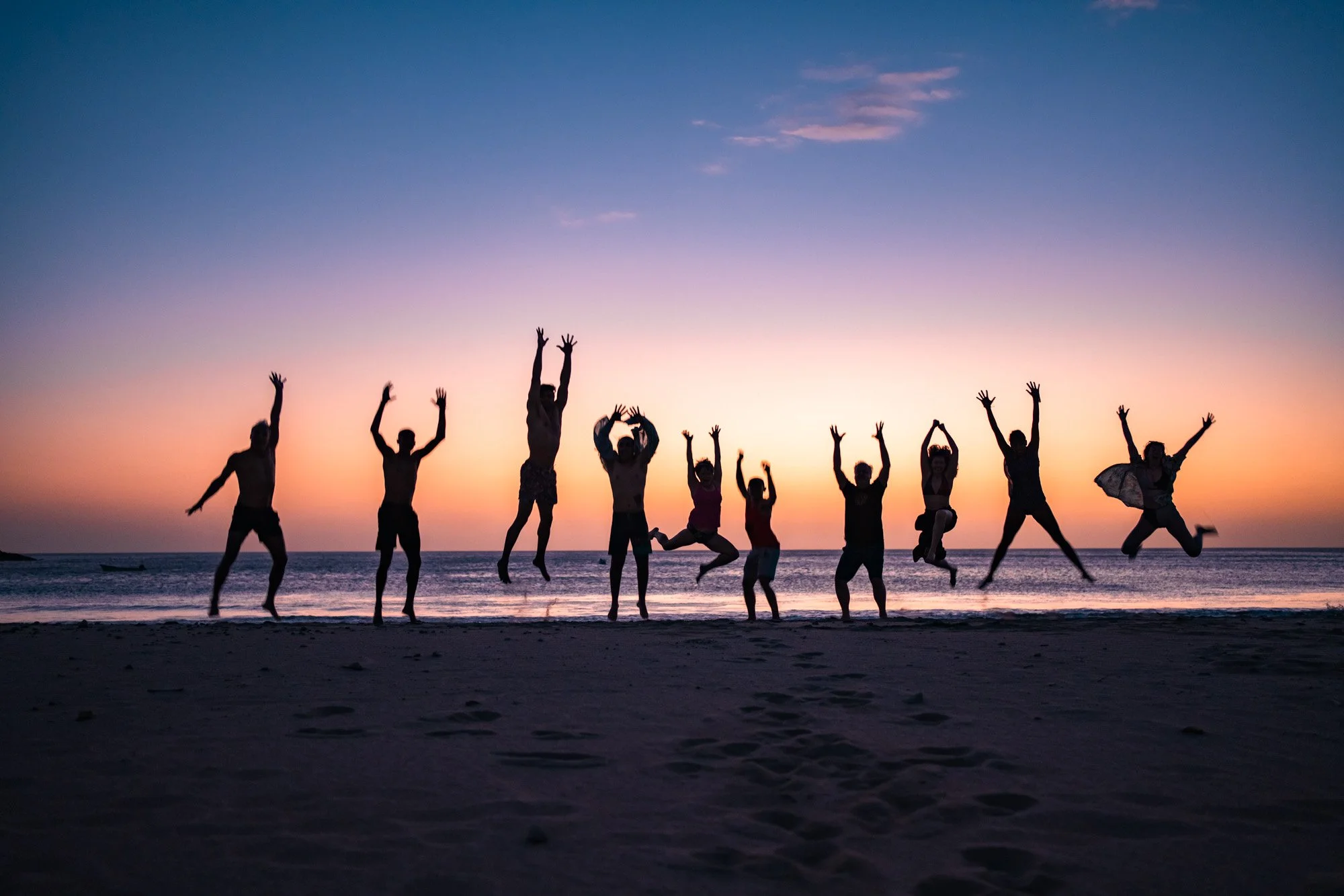 Group celebrating at sunset on retreat beach, wellness retreat photography Nova Scotia
