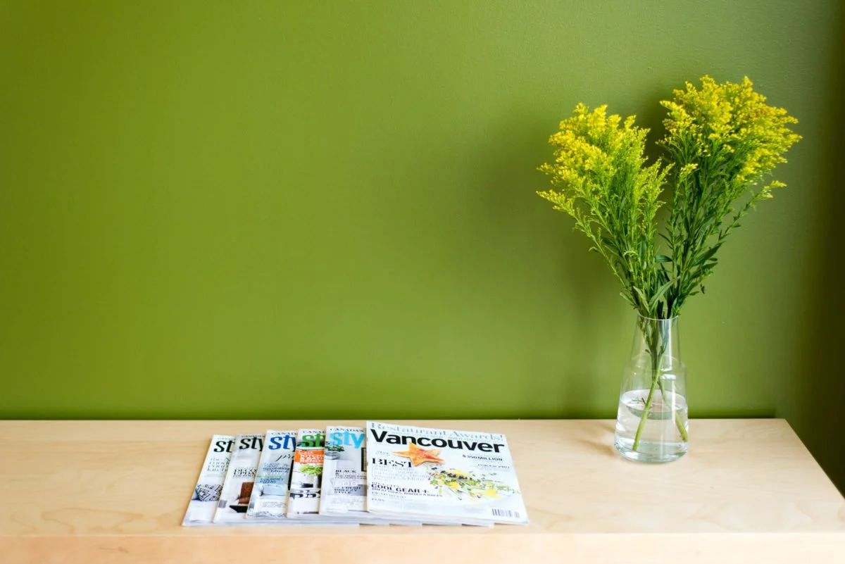 Green accent wall with magazines, interior design photography Vancouver