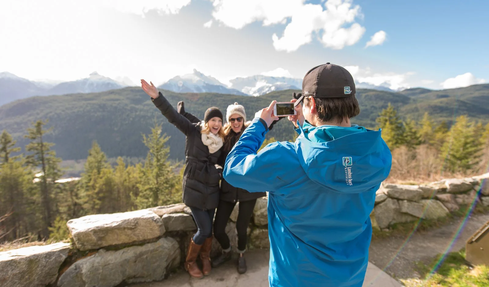 Tour guide taking photo of friends in front of mountain view, tour company branding photography